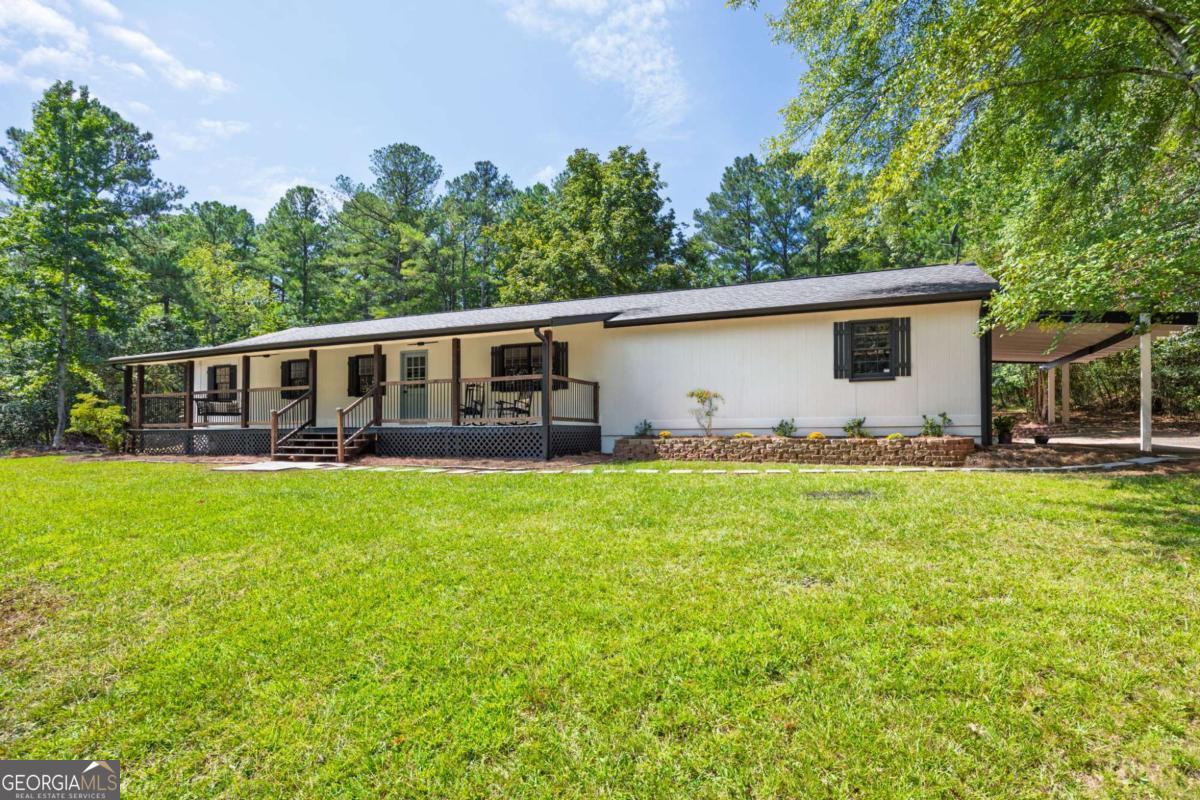 Discover your own private homestead on nearly 4 acres in sought-after North Paulding. This beautifully renovated single-level home offers three spacious bedrooms, two modern bathrooms, and a sunroom. With over $85,000 in improvements, every detail has been thoughtfully updated, including new LVP flooring, kitchen cabinets, appliances, bathrooms, lighting, PEX plumbing, HVAC, and septic. A two-car garage provides both convenience and storage. Outdoors, the lifestyle is unmatched. The enclosed garden is ready for your vegetables and flowers, while trails wind through the 3.7 wooded acres for you to explore. Deer make nightly visits, adding to the peaceful atmosphere, and both the covered back porch and the rocking-chair front porch provide relaxing spots to enjoy the surrounding nature. With no HOA restrictions, this property offers the freedom to create the homestead you've always dreamed of while still being close to top schools, parks, and amenities in North Paulding. This rare opportunity combines modern comfort, privacy, and room to grow-inside and out.
