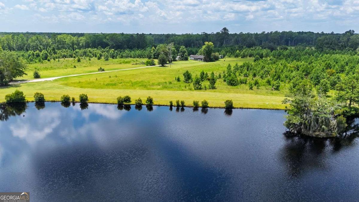 Peaceful Retreat with Endless Possibilities - 39.5 Acres in Effingham County! Peace. Quiet. Gorgeous land to roam and call home. This stunning 39.5-acre tract offers the perfect blend of privacy and convenience just outside of Guyton, Georgia. Whether you're dreaming of a serene country homestead or a weekend getaway, this property delivers. At the heart of the land is a beautiful 4.5-acre stocked pond-perfect for fishing, relaxing, or watching the sunset. Catch em, clean em, cook em... then its dinner time on your porch with a view! The property features a charming 1959 home with 1,563 sq. ft., 4 bedrooms, 2 baths, a vintage country kitchen, spacious dining room, and a massive walk-in pantry. A single-wide mobile home that's currently used for storage but offers additional flexibility. And rolling acreage with mature trees, ideal for building your dream home, gardening, or even hobby farming. You can choose to restore the original home, build new by the pond, or do both-using one as a guesthouse or rental. With this much land, the possibilities truly are endless. Don't miss your chance to own this rare piece of Georgia countryside. Schedule your private showing today and start imagining the future you can build here! (Home sold in As-Is Condition)