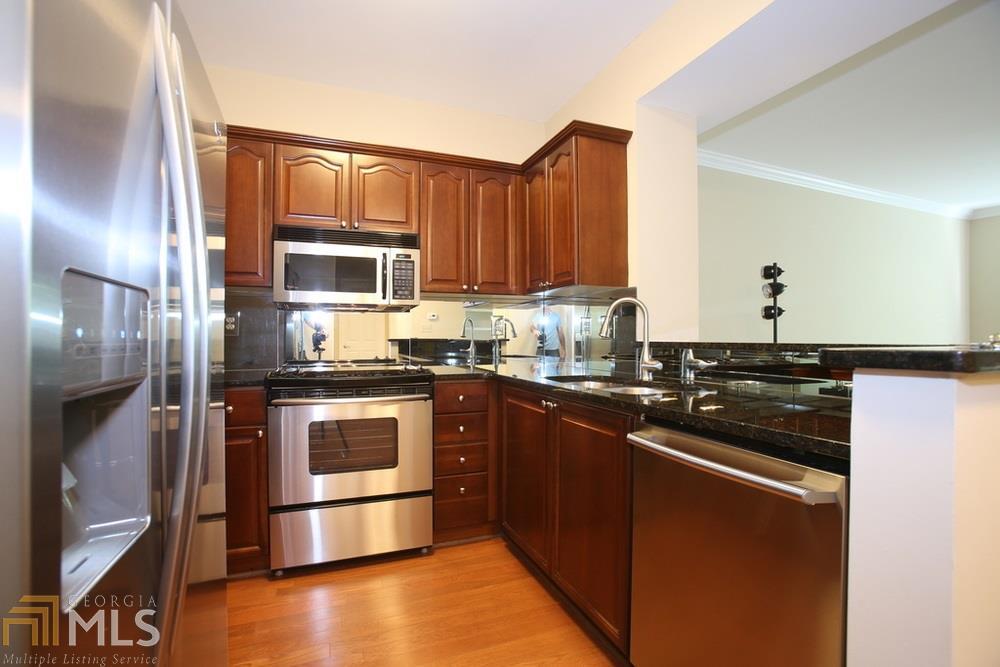 Gated Community in a Prime location. Just minutes to Cumberland/Galleria, 75/285 and Suntrust Park. Nestled in the trees and feeling more like a resort, this Corner unit has the Best location in the building. Private wrap around Balcony that overlooks a Beautiful Waterfall amenity. Unique Wide Open floor plan with everything upgraded. Fireplace, high ceilings, New Custom cabinets, Plantation shutters, top of the line appliances, Granite, Hardwoods, Large tiled shower, Walk in closet. Enjoy the professionally landscaped grounds, 2 Pools, Gym, Clubhouse, Pet Walk, and Covered parking.