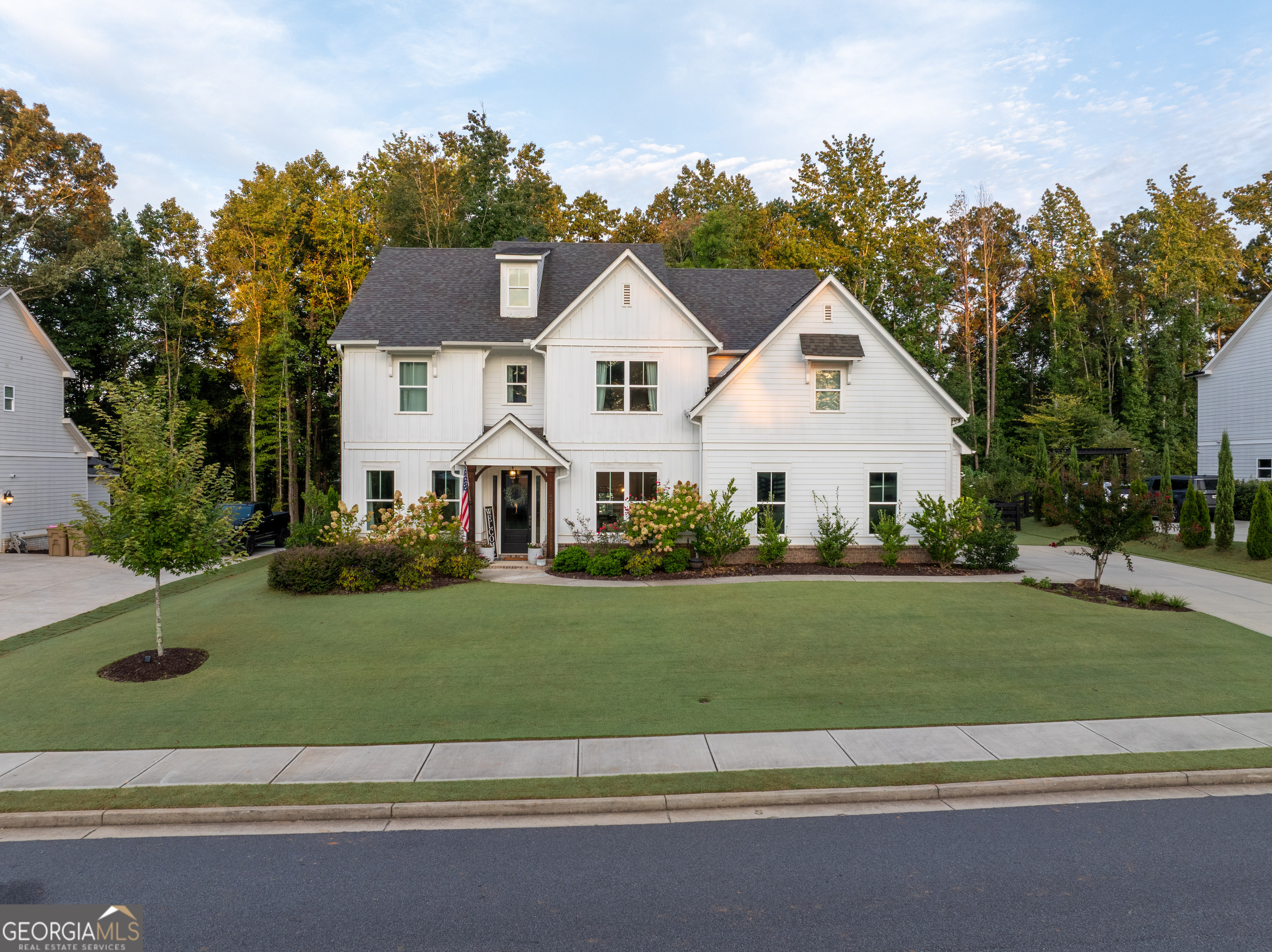 Stunning 2020 custom-built home offering almost 4k Sq Ft of meticulously designed living space with soaring 10' ceilings and elegant 8' doors throughout the main level. This 4-bedroom, 3.5-bathroom residence showcases premium finishes and thoughtful custom details at every turn. The chef-inspired kitchen is perfect for entertaining and features an oversized island with extensive storage, gas range, and seamless flow to a large walk-in custom butler's pantry complete with fully custom cabinetry, distinctive herringbone brick flooring, white oak countertops and a freezer. Built-in dry bar off the kitchen includes wine refrigerator for elegant entertaining. Mudroom provides organized living with custom-built cabinet lockers and drawers that offer plenty of storage. Formal dining room impresses with coffered ceiling and classic wainscoting, while the shiplap-adorned living room offers custom built-in shelving for sophisticated entertaining. Main level office features custom built-ins with drawers and white oak desktop for the perfect work-from-home environment. Playroom with closet provides flexible space that could serve as an additional bedroom. Powder room showcases Pottery Barn vanity and charming shiplap detailing. Upstairs, the primary suite has been upgraded with hardwoods and shiplap, complemented by expansive walk-in closets with custom shelving and abundant storage. Fully custom upstairs office includes hardwood flooring, built-in cabinetry, and electric fireplace for an inspiring retreat. Guest bedrooms feature board and batten accent walls, each thoughtfully designed for comfort and style for a large family. The professionally landscaped and fenced grounds create an entertainer's paradise with multiple outdoor living areas. Expansive covered deck off the kitchen flows seamlessly to a covered outdoor kitchen equipped with built-in griddle and smoker, granite countertops with storage underneath, and wall-mounted TV, all featuring elegant herringbone brick flooring. Two distinct firepit areas-one brick, one freestanding-anchor the beautifully designed outdoor spaces. Children's playground area features timber-framed mulch play zone for safe family fun. Brand new freestanding workshop building with electrical provides organized storage and functional workspace tucked away in the trees. Recreation enthusiasts will appreciate the 2-hole Bermuda putting green, perfect for honing your short game. Professional landscape lighting illuminates both front and backyard areas for year-round enjoyment. Three-car garage with large storage shelving completes this exceptional property, combining luxury living with practical functionality in a thoughtfully planned design.