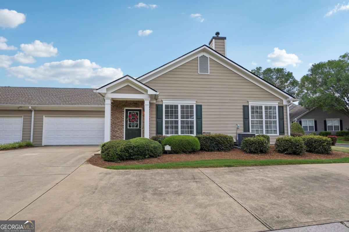Welcome to this charming 2 bedroom, 2 bath end unit townhouse in the 55+ community of The Villas at Evans Mill offering comfort and convenience in a beautifully maintained setting. Step inside to find high ceilings in the spacious living area that fill the home with natural light. The pristine white kitchen features under-cabinet lighting, a cozy breakfast area, and ample cabinet space. A separate laundry room adds extra functionality. The primary suite includes a large walk-in closet and a double vanity in the bathroom. Enjoy the ease of a 2-car garage and low-maintenance living, all in a quiet and well-kept community.