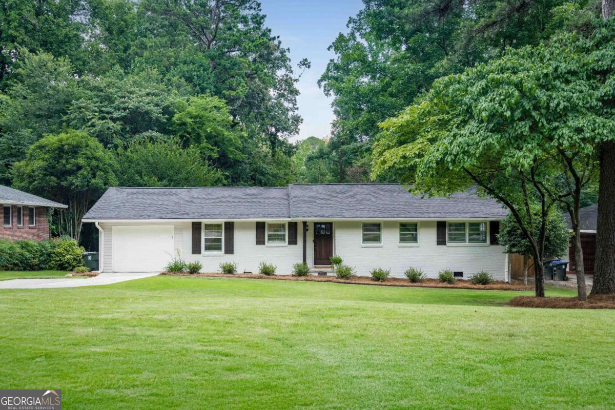 Say hello to 2617 Warwick Circle - a beautifully renovated brick ranch tucked away on arguably the best street in Wakefield Forest, one of Chamblee's best kept secrets and most beloved neighborhoods! With a hard-to-find one-car garage, a fresh new roof (only weeks old!), and fantastic backyard, this home is move-in ready and waiting for you. From the moment you arrive, charming curb appeal invites you into a thoughtfully updated home filled with character and modern conveniences. Fall in love with the warm hardwood floors, freshly updated finishes, and a flawless layout that's perfect for everything from casual nights into lively dinner parties. A cheery kitchen is equipped with white shaker cabinets, granite countertops, stainless appliances and cozy breakfast nook. A convenient door leads from the kitchen to the garage so unloading groceries doesn't become a gym workout! Flow seamlessly from the kitchen into the generous dining area, complete with built-in storage (hello, bonus pantry space!) and a stylish dry bar with wine fridge and butcher block countertop - yes, your brunch game just leveled up. It opens into a huge family room with a rare fireplace that's begging for movie nights or cozy hangouts. Slide out the back door to a freshly stained deck that's just calling for morning coffee, sunset cocktails and weekend grilling with friends. Enjoy a grassy, fenced backyard that's pup-approved and garden-ready. Plus, there's a cute storage shed out back for all your "I'll use this one day" stuff. Retreat to the primary bedroom boasting a spacious layout and renovated bathroom with double vanity, water closet, large shower with tile stretching to the ceiling and dual shower heads, and a custom closet with built-in shelving. Two more roomy bedrooms (one with its own private half bath!) and a second full bath complete the home. More perks include a bonus storage room off the garage and updated sewer line. Unbeatable location just 7 minutes to the shops and dining on Dresden Drive in Brookhaven Village, close to downtown Chamblee's festivals and summer concerts, and near parks-Dresden Park, Skyland Park (volleyball, anyone?), and even the Peachtree Creek Greenway. With easy access to MARTA, major highways, Buckhead, Decatur, and beyond, this one's got it all. Wakefield Forest offers the perfect blend between peaceful living and city convenience - a true hidden gem. Come see for yourself!