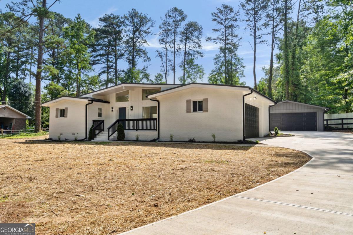 Don't miss a rare opportunity to own such a unique home and property located just minutes from the heart of East Cobb with interstate access. This fully renovated home features contemporary design with modern finishes. Located at the end of the street, this home will afford you all the privacy you have been looking for. You will be minutes from everything, but you will feel like you are miles away. As you approach, you will notice that you are surrounded by large lots with mature trees. As you pull in the drive, you will be excited to see not only the side entry garage, but an additional separate two-car garage that can be the wood or auto shop you always wanted. Step inside and find natural toned floors, black and gold metal features, and tall ceilings. The newly renovated kitchen boasts white modern cabinetry, quarts countertops, a subway tile splash, and stainless appliances. In addition to the three bedrooms, you will find two newly renovated bathrooms. Custom vanities, quartz tops, and custom tile surrounds really set this home part from the competition. Step out onto the brand new patio in the back to find a large, cleared lot that has been fenced in with a split rail fence, finished off to keep the pets in. Perfectly located right off Roswell Rd, this home gives you East Cobb status and instant access to the interstate for that quick commute to the city. Things are heating up this summer, and this house is pretty cool.