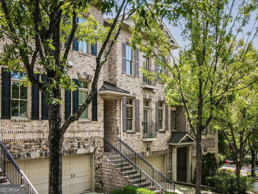 Executive Townhome in Prime Buckhead Location - Move-In Ready! Welcome to Pine Hills, a secure gated community of just 34 distinctive 4 side brick townhomes in the heart of Buckhead. Freshly painted with new designer lighting and gleaming hardwood floors throughout, this executive residence offers the perfect blend of style, space, and convenience. Enjoy an open floor plan ideal for entertaining, with seamless flow between the gourmet kitchen, dining, and living areas. The kitchen is outfitted with high-end appliances, custom finishes, and 9' solid wood doors that elevate the space. Step outside to your private balcony or covered patio for morning coffee or evening cocktails. Upstairs, you'll find two spacious primary suites-each with walk-in closets and spa-like baths. The terrace level offers a third bedroom with private access and a full bath, perfect for guests, a home office, or multigenerational living. A modern laundry room (washer and dryer included) and a two-car garage with abundant storage complete the package. All of this in an unbeatable Buckhead location with dining, shopping, and amenities just minutes away. Sophisticated, secure, and move-in ready.