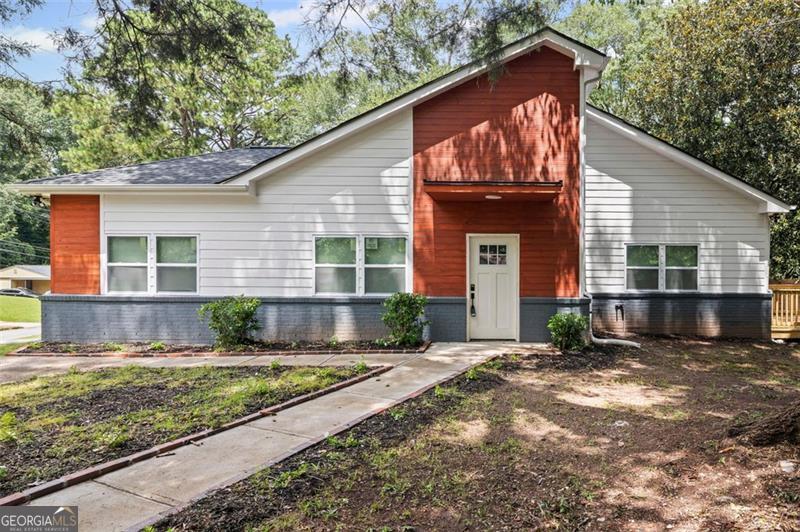 Step inside this completely renovated home where modern design meets timeless comfort. Taken down to the studs and rebuilt from the ground up, every inch of this property has been carefully crafted with high-quality finishes and thoughtful details. Boasting the largest square footage in the neighborhood, this home offers an expansive layout rarely found in the area. The kitchen is a true centerpiece, featuring walls of windows that drench the space in natural light, a generous island with seating for casual dining, gleaming quartz countertops, and brand-new stainless steel appliances that will delight any home chef. From the kitchen, the open-concept floor plan flows seamlessly into the dining area and the spacious family room, anchored by a sleek electric fireplace that serves as both a cozy gathering spot and an eye-catching design feature. The private primary suite offers a luxurious retreat with its spa-inspired bathroom, complete with a double vanity, an oversized standing shower with frameless glass, and premium tile work. Two additional bedrooms provide ample space for family, guests, or a home office, all served by beautifully updated bathrooms with modern fixtures and finishes. Step outside to the brand-new deck overlooking a fully fenced backyard-perfect for entertaining, gardening, or simply enjoying your morning coffee in peace. Every element of this home, from the new mechanical systems to the designer lighting, has been selected for style, comfort, and long-lasting value. Located just minutes from the freeway and less than ten minutes from Lakewood Amphitheatre, the Atlanta Airport, and a variety of shopping and dining destinations, this property offers an unbeatable combination of elegance, functionality, and convenience.
