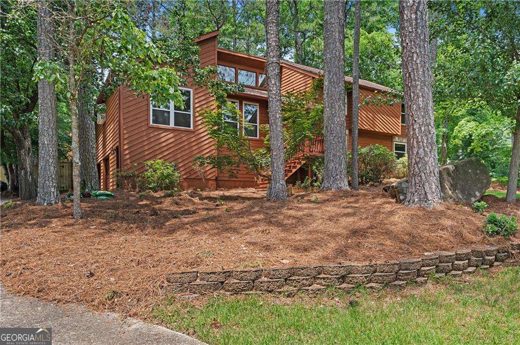 Enjoy a desirable open concept home w/beautiful light filled, highly functional rooms and massive fenced backyard! A welcoming entry joins a huge fireside great room w/fresh paint, gorgeous hardwoods, vaulted ceilings and new windows and sliding glass doors. This area leads to the family-sized dining area w/beamed accents+ceilng fans. Home cooks will enjoy the renovated kitchen w/fabulous tongue and groove ceiling, tons of storage in full height cabinetry, skylights, cooking island w/gas cooktop, huge pantry and eat-in kitchen area. Kitchen opens to coveted screened back porch overlooking the grilling deck and backyard. Journey upstairs to the lovely primary bedroom w/vaulted ceiling, oversized walk-in closet, and newer carpet. The charming renovated master bath has his/her sinks, A+ countertops, soaking jacuzzi tub, newer lighting/tile and walk-In shower. There are 2 great-sized upper level bedrooms + shared bath. Convenient upstairs laundry area. Venture downstairs to enjoy handsome tiled drop off mudroom at the garage entry. Full-sized terrace level boasts another full bedroom/office/play space+full renovated bath. Enjoy game day in this paneled entertainment area w/ full bar/fridge area and access to lower deck/exterior. PLUS, the garage is huge offering multi car parking + handymanCOs favorite workshop area and full-room storage. The home sits on a wonderful corner lot w/greenspace/woods and walkability. Well maintained systems, new windows and glass doors except lower level, fresh paint, newer water heater+ carpet, Wonderful location, school district, ease to shopping and interstates! Swim/tennis is accessed via neighboring subdivisions or East Cobb Swim/Tennis.