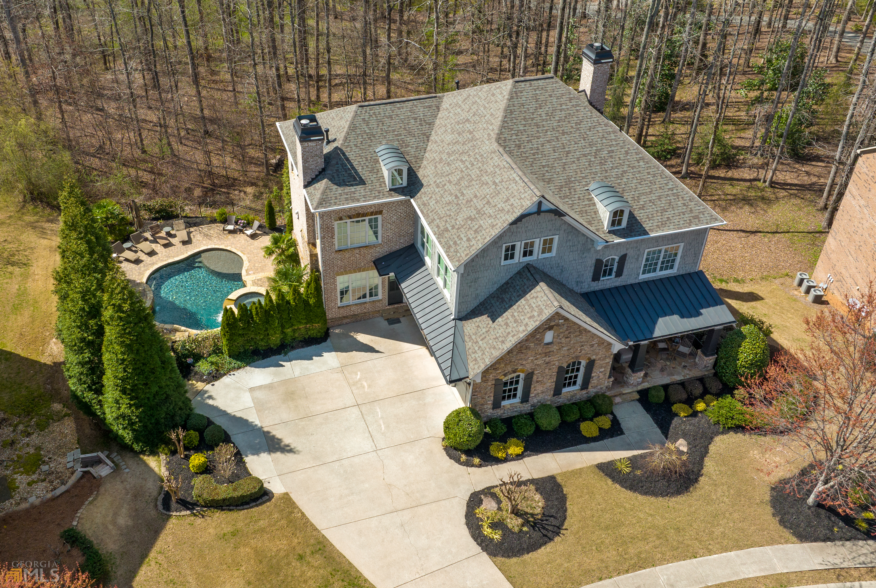 THIS RARE CUSTOM GEM WTH SALTWATER POOL & FINISHED TERRACE LEVEL IN GATED COMMUNITY, LAMBERT HIGH DISTRICT WILL SURPASS YOUR EXPECTATIONS. Modern interior design elements plus a backyard oasis result in the home you've been dreaming of! Each of the three finished levels of this home delight the senses. Modern white walls, subtle gray hardwoods, dramatic trim and custom built-ins, high-quality lighting, and fixtures adorn each room. The kitchen and each bathroom have undergone a complete transformation. Nothing remains untouched by these original owners. This is an entertainer's dream with an open floor plan from kitchen to keeping room, dining room, and family room. Walk out via French doors to your covered porch overlooking the pool with woods behind for privacy. Every room has been renovated. The kitchen has painted cabinets, Quartz counters, and new appliances. All new lighting. Each bathroom has new cabinetry, high-quality tile, lighting, and fixtures. The primary suite is upstairs and boasts custom cabinetry for clothing. The primary bath has heated tile floors and a steam shower. Three additional bedrooms upstairs plus bonus room. The guest suite on the main also makes a great home office. The finished terrace level has a gorgeous kitchen, two sitting areas, billiards area, bedroom, and full bath. Entry to the saltwater pool from the terrace. Such a peaceful place to relax or entertain. Gorgeous tree-lined views. The owners have poured their heart and soul (and pocketbook- over 500k) into this home. Now it could be yours to enjoy! Sought-after schools and location close to dining and shopping, easy access to GA 400 or 141. Close to several golf communities you can join. Welcome to the lifestyle you've earned.