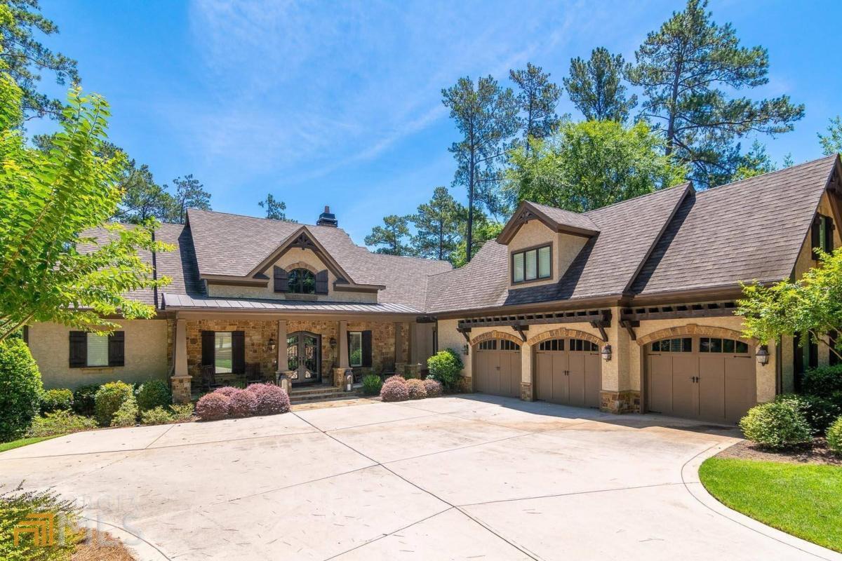 FULLY FURNISHED, MOVE-IN READY RENOVATED CUSTOM LAKE HOME AT REYNOLDS LAKE OCONEE MINUTES TO THE RITZ CARLTON WITH ABUNDANT OUTDOOR SPACE INCLUDING A BIG POOL, FIRE PIT, PRIVATE DOCK, OUTDOOR LIVING AND DINING AREAS AND EXPANSIVE SCREENED PORCH. This is your private lake paradise! This 5,653+ sqft home boasts 5 bedrooms, 5 bathrooms, 2 half baths, three car garage and all the amenities you could possibly think of in a lake house. Vaulted ceiling, beams, lake views welcome you when you walk into the great room with stone fireplace and an office, glass doors highlighting the water and takes you to out to the expansive porches overlooking the pool and the fabulous backyard. The gourmet well-appointed kitchen is open to the keeping room and the large dining room.You will enjoy the large screened porch, adjacent to the kitchen, overlooking the lake. The porch offers abundant space for living and dining area, allowing you to bring the outdoors in, all year round. Gorgeous master bedroom on the main level with spectacular lake views features private balcony and luxury master bathroom with large shower and custom closet. There is an oversized laundry room with two sets of washer/dryer and a sitting area. Above the three-car garage is a spacious apartment suite. Endless entertaining awaits in the terrace level featuring a spacious family/TV room, game room, full bar, wine cellar and three suites with private bathrooms. The lower level porch is to be desired with expansive covered dining area, a separate spacious covered living space, outdoor grill area, a large pool with tanning ledge, pool deck with additional sitting and lounging, and outdoor fire pit. The manicured backyard and beautiful mature landscaping was designed by Charles Miller. Enjoy your own private dock and kayak, paddle board or boat to the nearby Ritz Carlton resort and Lake Club. This property, which combines the perfect location, best outdoors, unparalleled amenities and laid back luxury is the dream lake home you've been waiting for. HOME WILL BE SOLD FURNISHED WITH SOME EXCLUSIONS. Golf membership is available.