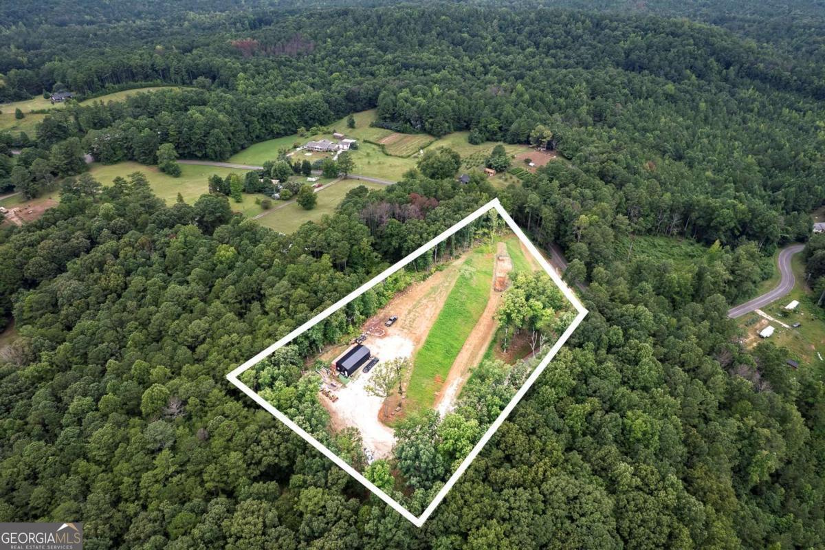 Discover the perfect canvas for your dream home on this stunning 2.8-acre parcel in the heart of Dallas. Set in a peaceful location with a paved driveway for easy access, this property offers sweeping views and a serene natural backdrop. Just steps from local wildlife, you'll enjoy a daily connection with nature while still being close to all the conveniences of town. Whether you envision a private retreat or a custom-built residence, this land provides the ideal blend of seclusion, beauty, and accessibility. Enjoy expansive views that capture the beauty of the surrounding landscape, along with the rare opportunity to observe deer, birds, and other wildlife right from your future porch. The gently rolling terrain provides an ideal building site, giving you flexibility in home design and orientation to take full advantage of the scenery. Nestled atop the landscape is a 40X18 metal building , equipped with a convenient garage door and a cozy office space, providing a head start for projects or storage needs. Detailed house plans are readily available as well as utilities, making the permit application and building process smoother and more cost-efficient. Whether you're dreaming of a private country retreat, a hobby farm, or a custom residence with room to roam, this property offers the perfect balance of privacy, natural beauty, and convenience.