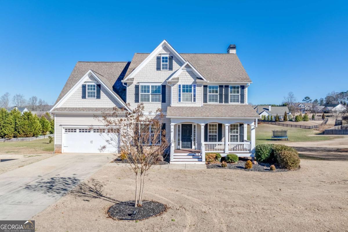 **Beautiful 4-Bedroom Home on Large Lot Near New Jackson County School Campus!** Welcome to this charming 4-bedroom, 2.5-bath two-story home located in the heart of Hoschton. Situated on a spacious lot with a large front yard and a huge backyard, this property offers plenty of room to relax, play, and entertain. The inviting covered front porch leads into a bright two-story foyer that sets the tone for the open, comfortable layout inside. The kitchen is a chef's delight featuring granite countertops, stained cabinets, a gas cooktop, double ovens, and a stainless steel refrigerator. The adjacent family spaces provide an easy flow for everyday living and entertaining. Upstairs, you'll find large secondary bedrooms with walk-in closets and a generous owner's suite with a spa-like bath, complete with a soaking tub and dual vanities. Enjoy peaceful mornings or evening gatherings on the screened back porch overlooking the expansive backyard. The unfinished walkout basement-already stubbed for a bath-offers endless potential for future expansion. Additional highlights include a two-car garage and a prime location less than one mile from the new Jackson County Schools campus. This is the perfect blend of comfort, convenience, and value in a highly sought-after area!