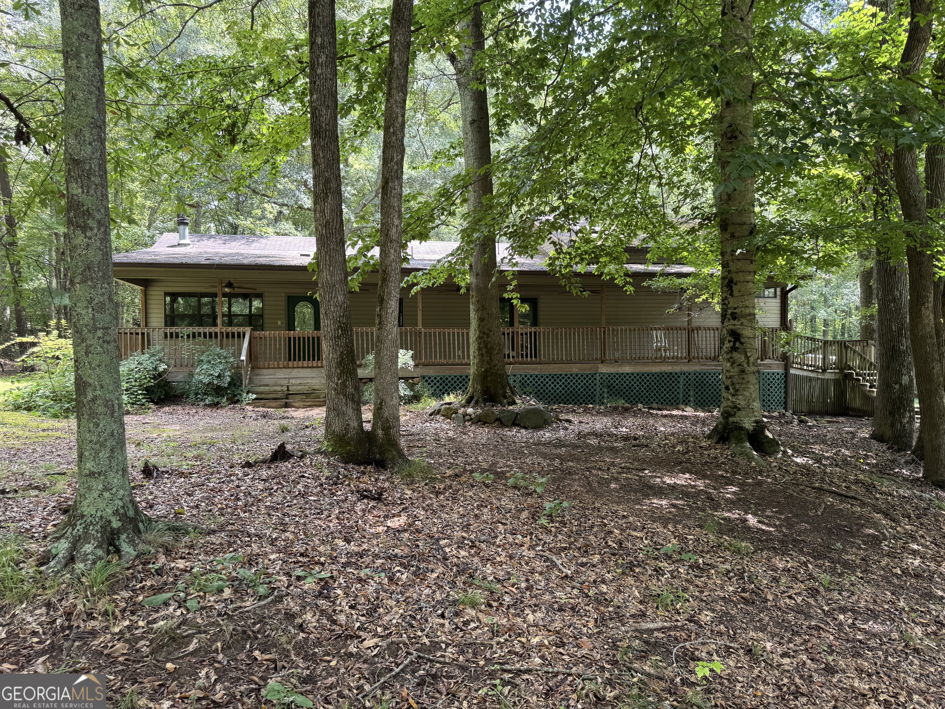 Very private, wooded, 21+ acres plus 3 bedroom, 2 bath ranch home. Land partially cleared. Barn. Land is suitable for farming and hunting. Creek runs through property. Home features, both family room and den. Hugh porch spans the entire front of the home. Public water, but 2 wells on the property. 2 car garage.