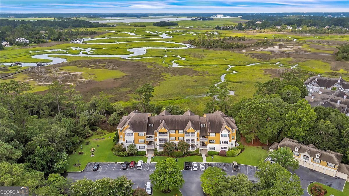Experience million dollar views from this top floor, renovated "lock and leave" condo in a gated, waterfront community just 15 minutes from the sandy beaches of Tybee Island! Enjoy unobstructed marsh views and magnificent riverside sunsets from every room in this newly remodeled Whitemarsh Island condo. Watch boats drift along the Wilmington River and water birds wade through shimmering creeks from either bedroom or the sunroom. This cheerful 2 bed, 2 bath home features an open floor plan with smooth, vaulted ceilings throughout (no popcorn!), fresh light paint, and new, easy-care floors. Updated lighting, hardware, and ceiling fans add to the bright, modern feel. The living space feels oversized, with an adjacent sunroom and open nook that could be a bar space or a small office. The kitchen boasts granite countertops, stainless steel appliances, a touchless faucet, and pantry with ample storage. Separate dining space with room for 6-8. The spacious primary suite has stunning marsh views, a walk-in closet, and beautifully updated bath. Secondary suite also boasts views of the marsh. Mercer Point offers gated entry, pool, clubhouse, tennis, playground, and boat parking. Ideal location just minutes to Tybee Island Beach, Historic Downtown Savannah, top rated elementary schools, shopping, and most importantly- access to the water and boat ramps! 2 bed/2 bath units rent for $2k+ in this community; 6 month minimum rental for Mercer Point. Drive back from the beach or hop off the boat, cool off in the neighborhood pool, and enjoy a carefree lifestyle.