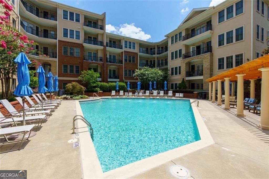 Walk to Vinings Jubilee, top-rated restaurants, boutique shops, and more. Experience the best of live/work/play in one of Atlanta's most charming neighborhoods! Beautifully Maintained Condo Overlooking the Pool in the Heart of Historic Vinings! Located in the highly sought-after Vinings Main community, this light-filled condo w/10 Foot Ceilings throughout offers an unbeatable blend of style, comfort, and convenience. Featuring rich hardwood floors, white cabinetry, granite countertops, and stainless steel appliances, the open-concept living space is perfect for everyday living and entertaining. The spacious Owner's Suite includes a walk-in closet, double vanities, a soaking tub, and a separate shower. Enjoy resort-style amenities including a concierge, fitness center, swimming pool, club room, guest suite, gated entry, dog walk, and one deeded, covered, secure parking space. Ideally situated on the concierge level, this unit offers immediate access to the front desk, mailroom, gym, and guest suite - all just steps from your door. Water heater replaced in 2024.