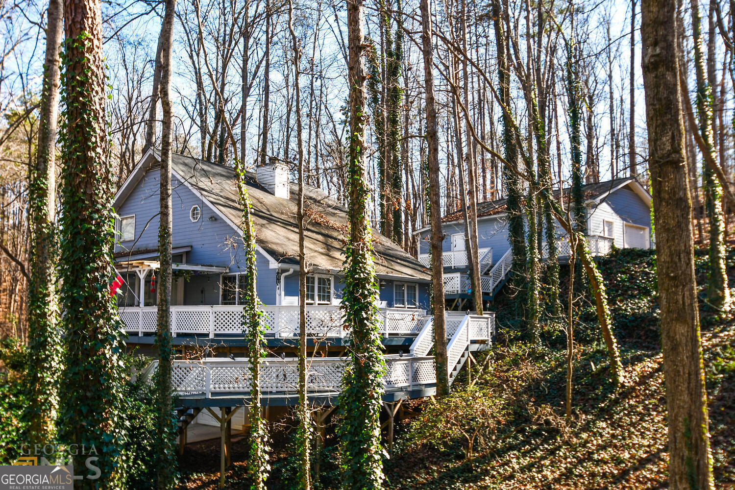 Tucked away in the peaceful Lake Lanier neighborhood of Surfside Club Estates, this updated 2-bedroom, 2-bath cottage is full of charm and comfort-just minutes from downtown Gainesville. Inside, you'll find a bright and welcoming two-story family room, an open-concept layout, and a sunny bonus room perfect for relaxing or working from home. There are two fireplaces to enjoy-one in the main living space and another in the primary bedroom, which also opens to a private screened-in deck with peaceful wooded views. Out back, the spacious deck is ideal for morning coffee, evening hangouts, or weekend get-togethers. Need extra space? The detached 2-car garage doubles as a flexible bonus area with room for beds, a TV, fridge, and games-great for guests or a fun hangout spot. Set in a quiet, friendly community near Lake Lanier, this home is a comfortable escape with room to make it your own. Come see it for yourself!