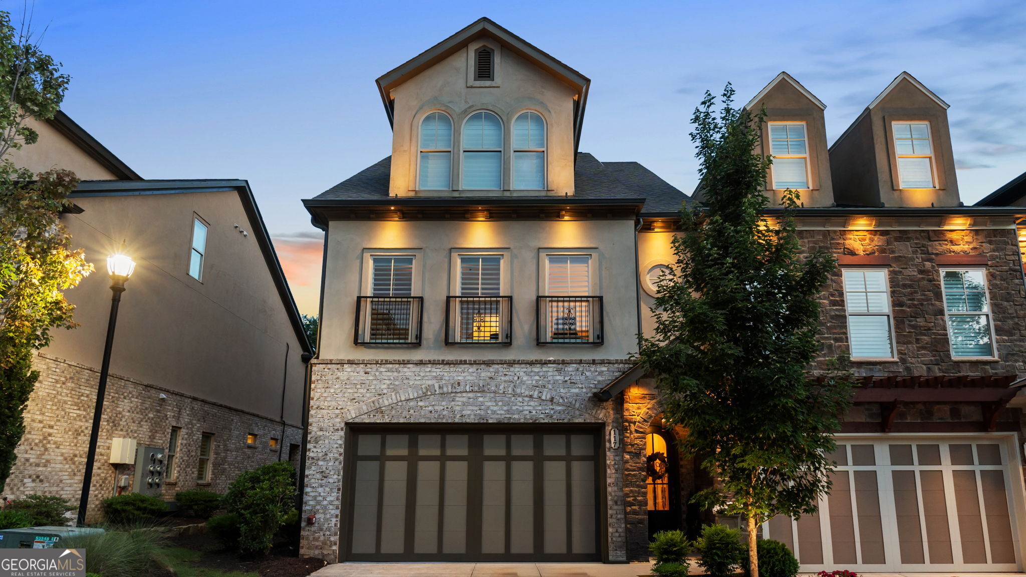 Welcome to the most beautiful end unit townhome with a Hydraulic elevator and the highest end luxury finishes throughout the residence in this amazing gated community, Tuscany Village. One of the original floor plans, the Cortona features 3,400 square feet with bullnosed walls, barrel archways, curved staircases and so much more. As you walk through the front door you will fall in love with the arched front door, archway and details that lead you into your new home. The Kitchen is sure to impress with the unique two-story ceiling, 42" full overlay Shaker cabinetry, new custom countertops, Stainless Steel hood with tile to the ceiling, large island, Stainless Steel appliances, gas cooktop and new faucet. The open view to the Dining Room with remote controlled shades and transom windows provide amazing light to your private landscaped backyard. The Great Room is perfect with a coffered ceiling, gas fireplace and large bi-fold sliders that open to the expanded patio. This enlarged curved patio features beautiful landscaping, a remote-controlled privacy shade from the covered sitting area and is the perfect place to grill out all summer or have a relaxing afternoon. The elevator, or curved staircase, leads to the second floor that features a spacious owner's suite with a gas fireplace, gorgeous circular tray ceiling, wall trim details and two separate walk-in closets. The owner's bath will be the perfect place to relax with a free-standing tub, walk-in tile shower and two separate vanities with custom countertops and new lighted mirrors. The two secondary bedrooms on this floor share a beautiful hall bath with walk-in shower. The laundry room is conveniently located in the hallway with a large sink and cabinetry. Upstairs on the third floor you will fall in love with the large entertainment space that includes an additional fireplace, half bath and upgraded French doors that lead to the expansive rooftop deck with private wooded views. The top floor lounge offers luxury and privacy with the rooftop space like no other. The upgraded railings were just added and if you want a second kitchen, the plumbing are already in the lounge area. The third floor also includes an oversize bedroom with sitting area, walk-in closet and ensuite bath. The elevator is easily accessible to all three floors. The upgraded light fixtures, new countertops, new mirrors, new faucets, remote controlled shades, plantation shutters and new open metal railings on the rooftop deck are a few of the latest touches you will enjoy. You will fall in love with the distinctive details in this property. You won't want to miss out on 117 Via Roma near downtown Woodstock. You can enjoy walking out of the front community gate and walking or biking to all that downtown Woodstock has to offer. Also conveniently located near grocery stores, restaurants, shopping and Highway 92, you can easily access heading into Atlanta or heading north to the Georgia Mountains anytime. Welcome home!