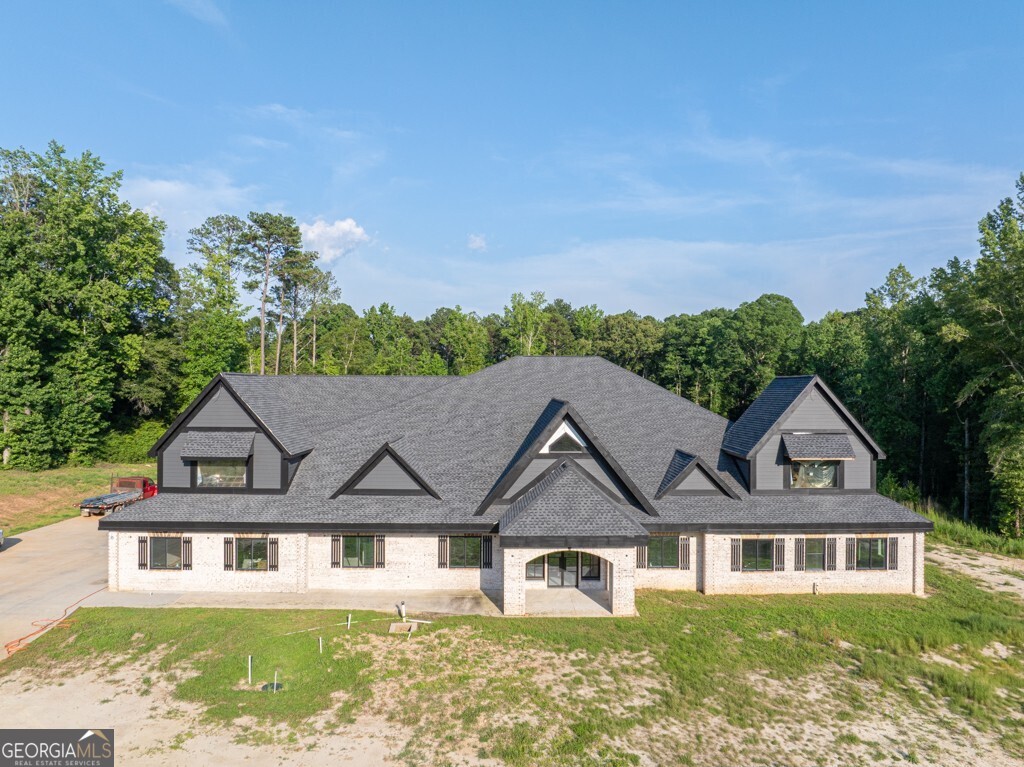 Magnificent, Amazing, Quality... These are just a few of the words used to describe this New Construction home located in Loganville, GA. Boasting 9 bedrooms, 7 full bathrooms, and 3 powder rooms. All bedrooms, including the Primary suite, are located on the main floor along with a formal living room, family room, Dining room fit for 20, Craft room, Office, Personal Gym prewired for a Sauna, Oversized laundry equipped with 3 laundry hooks ups plus a dog washing station. The oversized kitchen is set for a large island, two ovens, oversized stove, 2 built-in microwaves, pre plumbed coffee nook, spaced for Subzero Refrigerator. Butler's pantry leads into a truly oversized pantry wired for 2 additional freezers. My personal favorite part of the home is the Primary Suite. Floor-to-ceiling fireplace, Walk-in shower for 2 (really could fit way more!) Overhead Rain waterfall with two shower hooks ups, Step up Jacuzzi tub with waterfall accent wall, 3 vanities, and a TWO STORY Closet!!! Space GALORE! There are truly far too many details to list but this home is well thought out and is a must-see. The Seller has dedicated one room as headquarters to go and adjust all the functionality of the home. Also, there is another room dedicated to all the drawings/ engineering of the home so if there is ever a malfunction it can easily be located. There is another room which is also a favorite of mine, and that is the Decorations room!! You can easily move all of your holiday decor to one room, shut the door, and be ready for the next season. The house has been fitted for 5 HVAC units, 2 Water heaters, and has 2 septic systems installed. Upstairs is truly an entertainer's dream equipped with a room for Video Gaming, A full game room space, A cathedral-style theater, and a full Kitchenette. Also upstairs is another flex room or could be a 10th bedroom, full bath, and powder room. Are you a Car Enthusiast? Great because we have you covered with an 8-car garage prewired with an electric charging station for your car and your motorcycles! Outside of the home as you wander almost 11 acres you will find a 3200-square-foot shop fully run with power, water, and a powder room. Several fenced-in areas to home all your furry friends! Pastures, chicken coops, and pig pens on site! And we can't forget about the custom-built dog palace alongside the fenced-in pasture! Please check out the Virtual Tour attached to get a better idea of truly how amazing this home and property are! Sales price has increased due to completion of insulation and Sheetrock in the home. Next week seller will order tile and flooring for bathrooms as well. Seller would prefer to sell unfinished however can negotiate with buyer to complete home. Price is subject to change as seller is continuously working on property and home. There is still time to customize this home to your taste, so act fast to finish out your dream home.