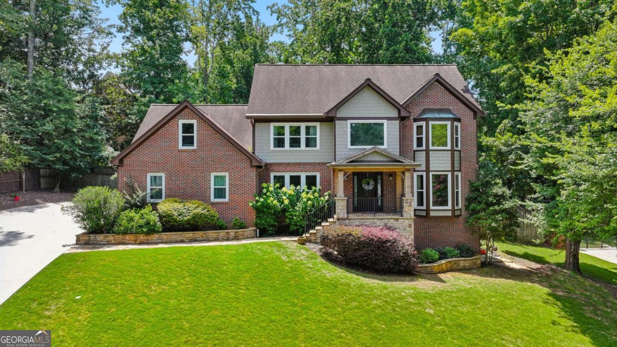 Prime location, stunning curb appeal and a charming, move-in ready interior! 1208 Dunbrooke Lane is right in the heart of Dunwoody and super close to the award-winning Austin Elementary School and Dunwoody Village. It doesn't stop there. This home was originally built as the personal home for the neighborhood's builder, with updates over time, including freshly refinished hardwoods on the first floor. From the outside, you'll notice new exterior finishes and a welcoming portico. Upon entering, the grand two-story foyer will be love at first sight. The first floor shows off the freshly refinished hardwood floors and an abundance of natural light. The bright kitchen features a window overlooking the backyard and floor to ceiling windows in the breakfast area. Natural stone countertops and plenty of cabinet space complete the dream kitchen with views of the gorgeous backyard. The adjacent living room includes a beautiful fireplace with built-in bookshelves on each side. The floor to ceiling wall paneling elevates the space, and the sliding glass door provides access to an idyllic screened porch. The first floor also includes a separate dining room, office, powder room, laundry room and access to the 2-car garage. With a choice of the front staircase or the rear staircase, the upstairs includes spacious bedrooms and the primary suite. The primary suite is a peaceful retreat with a beautiful bathroom, including dual vanities, a soaking tub, and a separate tiled shower, and a walk-in closet. Down the hall, you'll find three more bedrooms, including a versatile space at the end of the hall that could be a guest suite, bonus room, or office with a walk-in closet and access to the main floor via the back staircase. The unfinished basement offers endless possibilities, featuring a unique "boat door" for extra vehicles or space for a workshop or gym. Enjoy exceptional living on a private street, just a stone's throw from Dunwoody Village, the Dunwoody Nature Center, Austin Elementary, and the new Wildcat Park.