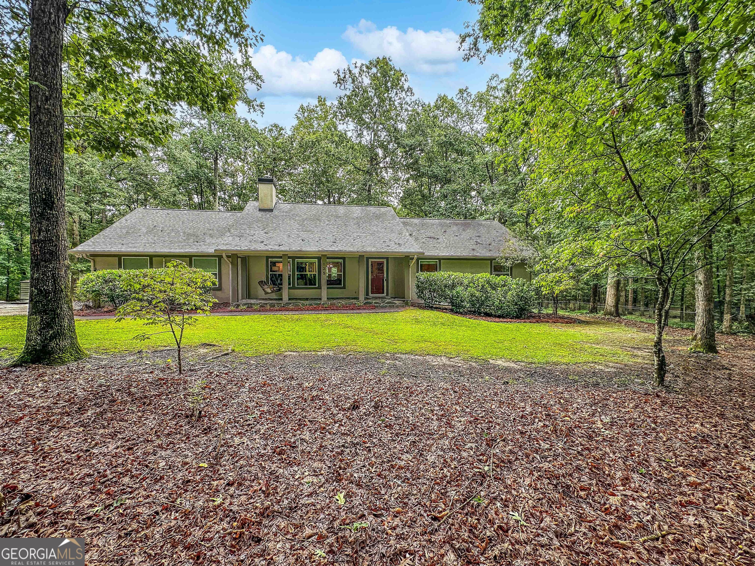 Welcome to this immaculate, custom-built ranch nestled on 2 beautifully landscaped acres in a prime Fayette County location! Offering over 2,000 square feet of living space, this thoughtfully designed home features four spacious bedrooms, three full bathrooms, a formal living and dining room and a separate den/office/media room! The eat-in kitchen is warm and inviting, showcasing tile countertops and ample cabinet space. Step outside to enjoy a charming covered front porch, relaxing back deck, a screened-in porch, and a partially fenced yard-ideal for outdoor entertaining or quiet mornings. There is an exterior access only basement/stand up crawl space used for storage, water heater and other supplies. The private backyard is a gardener's dream with mature trees, lush grass, and an abundance of perennial flowers and shrubs. Additional highlights include laundry room, all updated windows, fresh paint, and a partial basement with an exterior entrance-ideal for storage or a workshop. Tucked away in one of Fayette County's best-kept secrets, this property offers the perfect balance of privacy and convenience-just 20 minutes from the airport and close to top-rated schools, shopping, and more. Property is on well but public water is available at street. Homes like this don't come around often-schedule your showing today before it's gone!