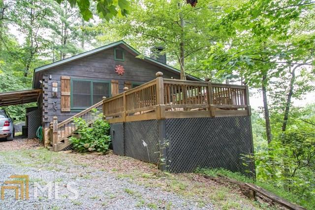 Let this inviting, true, log cabin wrap itself around you and feel the stress melt away! Wonderfully situated to maintain that tucked-in-the-woods feel and a great view. Covered porch plus an open deck to enjoy those clear sky mountain evenings. When you're finished stargazing, enjoy all of this cabin's indoor comforts- the open living space with fireplace; the oversized master bedroom with plenty of room for a king-sized bed plus sitting area, large 2nd bedroom, and laundry area/pantry. Covered parking is just a nice bonus.