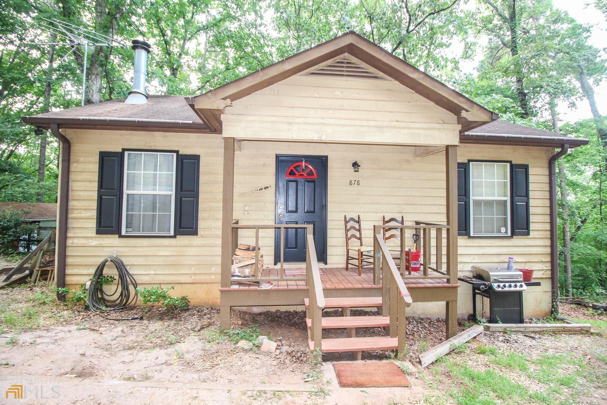 Looking for rural seclusion in the throes of the north Georgia mountains? This is the epitome of country-style living but located only 5 minutes from all the conveniences of Cleveland. This cute little bungalow possesses a really efficient floor plan, boasting open concept kitchen and family room, with real wood burning fireplace, and master suite on main, which has a small balcony perfect for enjoying that morning cup of Joe. Full terrace level offers nice sized laundry room, with second bedroom (no window) and full bath, plus large recreational room which features bar/kitchenette and access to the private, wooded backyard and fire pit. Property has 2 outbuildings and an RV parking spot. AND only 5 minutes from Helen!