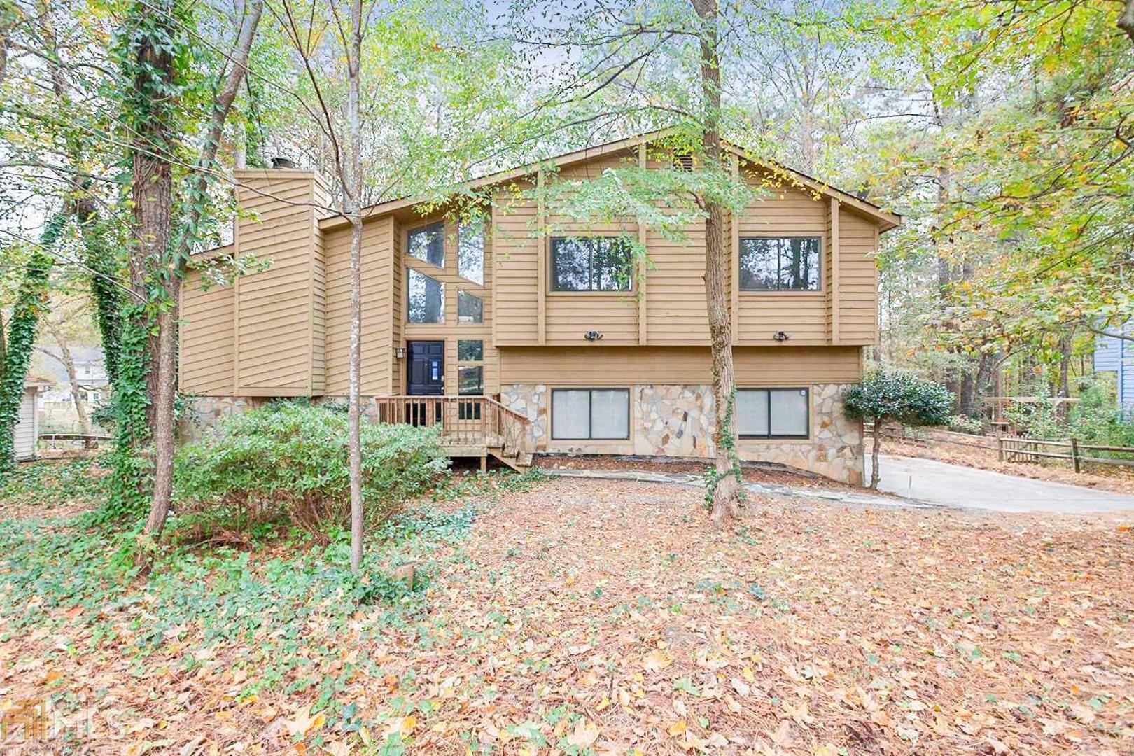 This Norcross two-story home offers a den, gas fireplace, kitchen breakfast bar, master walk-in closet, master bathroom dual sinks, separate tub and shower, open deck, covered patio, and a two-car garage, and a septic tank.