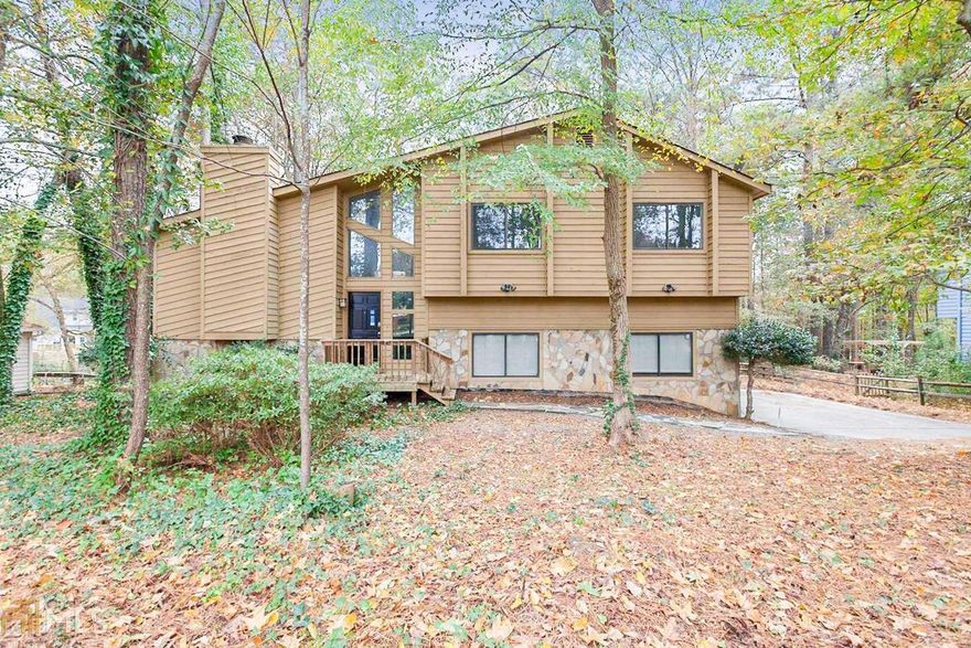 This Norcross two-story home offers a den, gas fireplace, kitchen breakfast bar, master walk-in closet, master bathroom dual sinks, separate tub and shower, open deck, covered patio, and a two-car garage, and a septic tank.