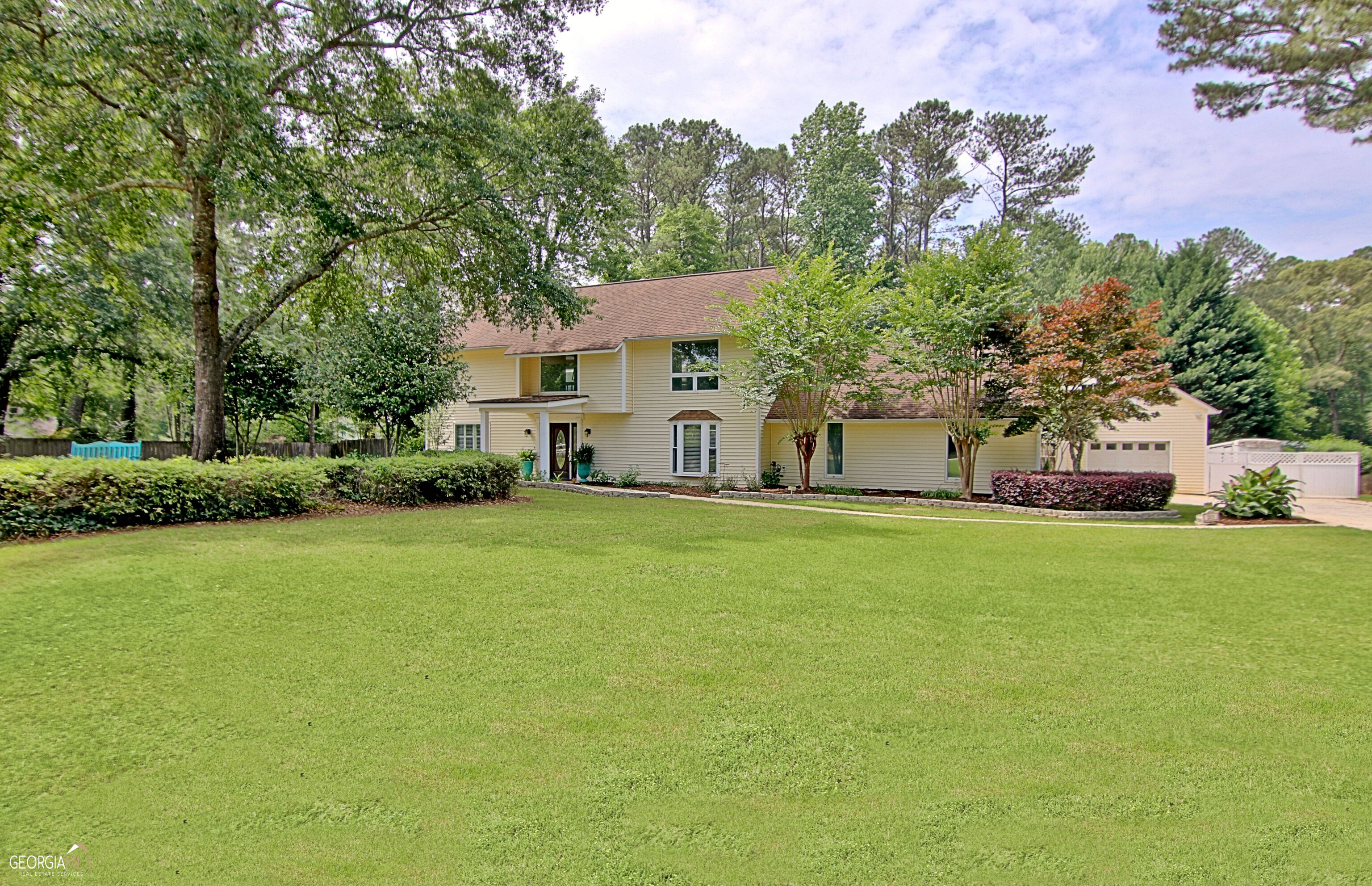 Search no more! Wonderful four bedroom home in the heart of Peachtree City situated on 3/4 acre lot with so much to offer. Two story entry foyer, oversized living room with fireplace, dining room, family room, and half bath. The kitchen has granite counters and KitchenAid stainless appliances. Kitchen opens to family room/den. Primary bedroom suite and three additional bedrooms on second floor. Second floor hall bath. Mud room/laundry entry from two car attached garage. Need more space for parking, storage, workshop, future bonus space? The detached 24' x 32' two story garage is serviced with power on both levels. Main level garage is sheet rocked, perfect for additional car/boat/golf cart parking. Need parking for your RV/camper? The side parking pad has 50-amp service and has a gate for easy access. The second level of the detached garage offers potential for future use or storage. The outdoor living space is amazing. Covered porches, huge pergola and outdoor kitchen provide spaces for lounging and entertaining. A beautiful Koi Pond and water features provide a sense of peace and tranquility. Perennials and mature landscaping grace the property. Minutes to Trilith Studios, convenient commute to Atlanta's Hartsfield Jackson Airport. Enjoy Peachtree City's golf cart paths connecting you to parks, lakes, restaurants, schools. Showings begin 5/26! Don't miss out on this one!