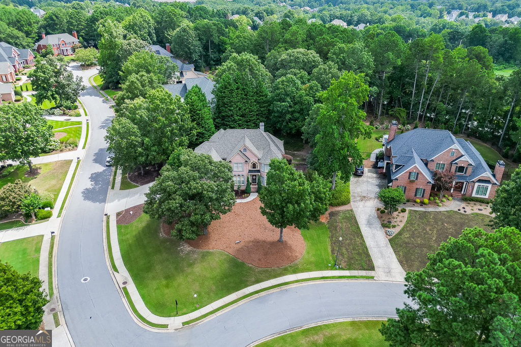 Beautiful home in the Executive style section of Town Manor in Hamilton Mill. This large open concept home has an updated kitchen looking into a spacious 2 story family room. The main floor includes a large dining room and family / flex room as well as an additional guest bedroom and full bath. Just beside the three car garage is a mud room / laundry room that carries its own full bath as well. The large master suite upstairs includes a sitting area and a spacious master bath and master closet to match. One secondary bedroom has a private bath, while the other two bedrooms share a Jack-n-Jill bath. The finished basement features a theatre room, with additional room that can be set up to fit any buyer's needs. There is also an additional bedroom and bath as well. The house sits on a large corner lot and has open free space for kids to play just across the street. Mill Creek school cluster. Amenities include two pool, 14 tennis courts, 6 pickleball courts, a soccer field and more.
