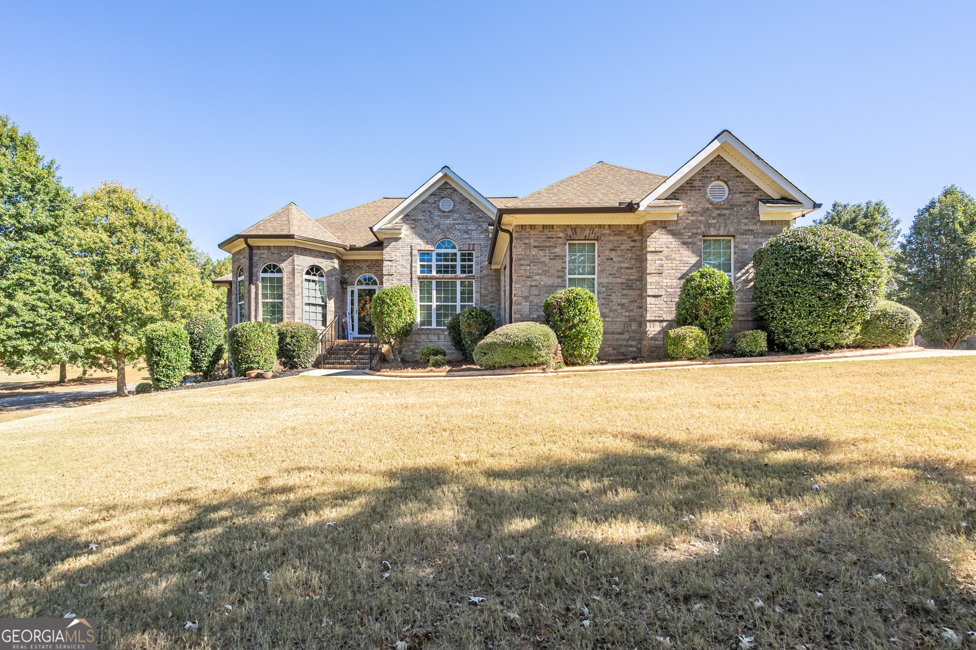 Located in the highly sought-after Indian Creek Overlook neighborhood, this stunning 4-sided brick home offers 4 bedrooms, 3.5 bathrooms, and sits on over 1 acre in a private cul-de-sac. The main level features an open floor plan with high vaulted ceilings, a cozy family room with gas log fireplace, and large windows that fill the home with natural sunlight. The eat-in kitchen includes stainless steel appliances and opens to a separate formal dining room, perfect for entertaining. The spacious owner's suite includes a private sitting area, his and her closets, and a large bathroom with dual vanities and a jetted whirlpool tub. On the opposite side of the home, two large bedrooms share a Jack and Jill bathroom. The finished basement offers a fourth bedroom and three additional multi-use rooms-ideal for an office, gym, or media room. Enjoy outdoor living on the covered back deck overlooking the in-ground saltwater pool. A separate driveway leads to a boat garage and full workshop, providing plenty of storage and workspace. This home combines comfort, space, and convenience in one of Henry County's most desirable areas-zoned for top-rated Union Grove schools. There is no HOA in this community.
