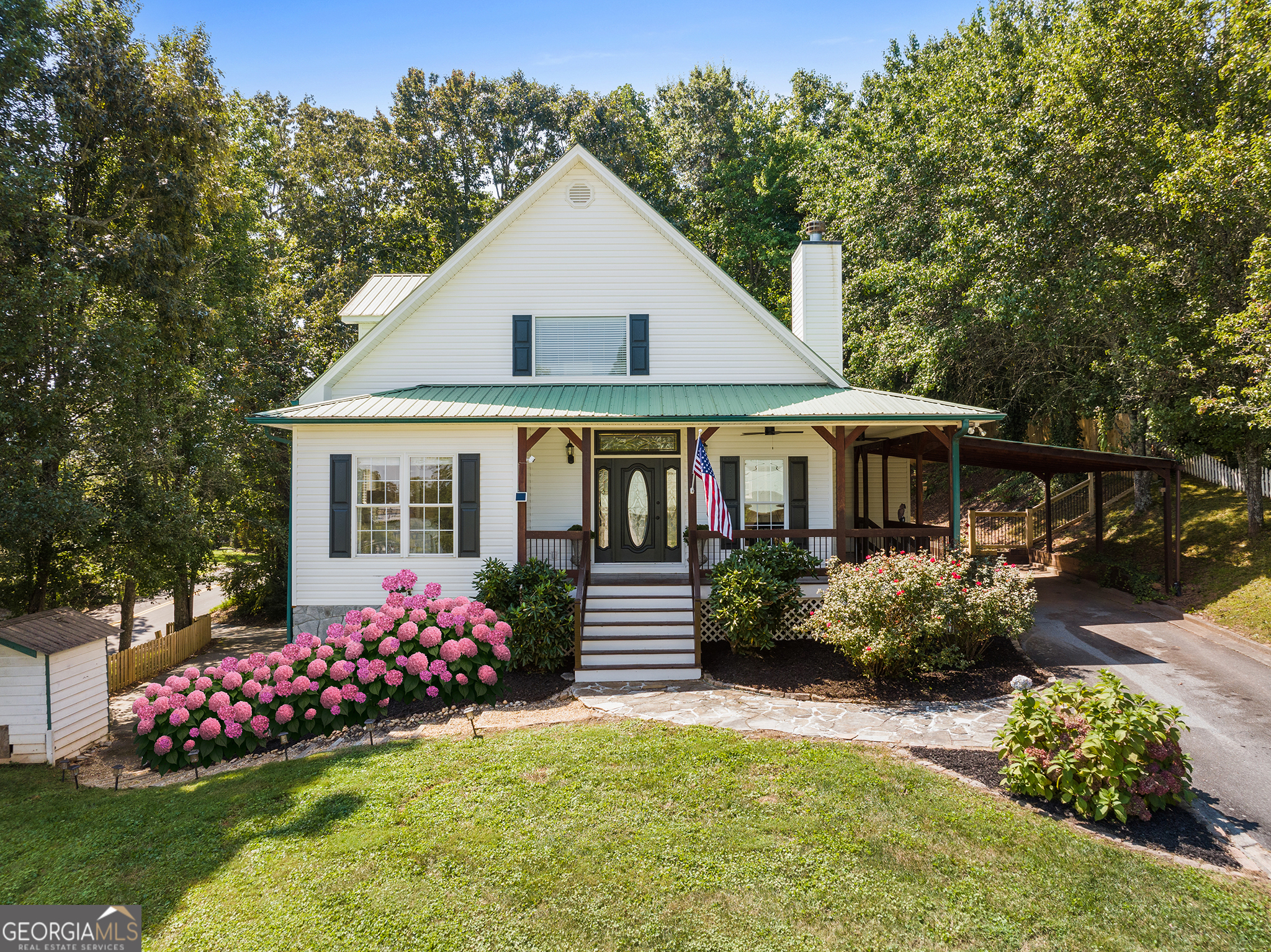 Wake up each day to the charm of downtown Blue Ridge just outside your door. This 4-bedroom, 4-bath home offers more than a place to live, it delivers a lifestyle, blending luxury finishes, mountain-town character, and an unbeatable walk-to-town location. Just two blocks from Main Street, enjoy your morning coffee at a local coffee shop, browse boutique shops, explore nearby parks, or take in seasonal festivals, all within minutes of home. Inside, expansive windows fill the home with natural light, perfectly framing year-round mountain views and a stunning vantage point of downtown. At the heart of the home, the open-concept living room boasts soaring vaulted ceilings and a striking fireplace that creates a warm, inviting centerpiece. The seamless connection between the living, dining, and well-appointed kitchen makes this space ideal for everything from cozy nights by the fire to lively gatherings with friends. The primary suite and a second bedroom on the main floor offer convenience and comfort, with rich hardwood floors adding timeless elegance. Follow the handcrafted staircase to find two spacious upstairs bedrooms with a shared bath, perfect for family or guests. The finished basement offers flexible space for a media room, office, gym, or additional guest accommodations, and includes a two-car garage with a second private driveway access. A main-level carport provides even more parking convenience. Step outside to the beautifully landscaped, fenced backyard, your private tranquil haven. Whether it's morning coffee on the porch, evening wine or smores by the firepit, or a weekend gathering under the stars, this outdoor space is designed for both relaxation and entertaining. This is more than a home, it's the essence of in town Blue Ridge living, where breathtaking mountain sunsets and walkable small-town charm meet in perfect harmony.