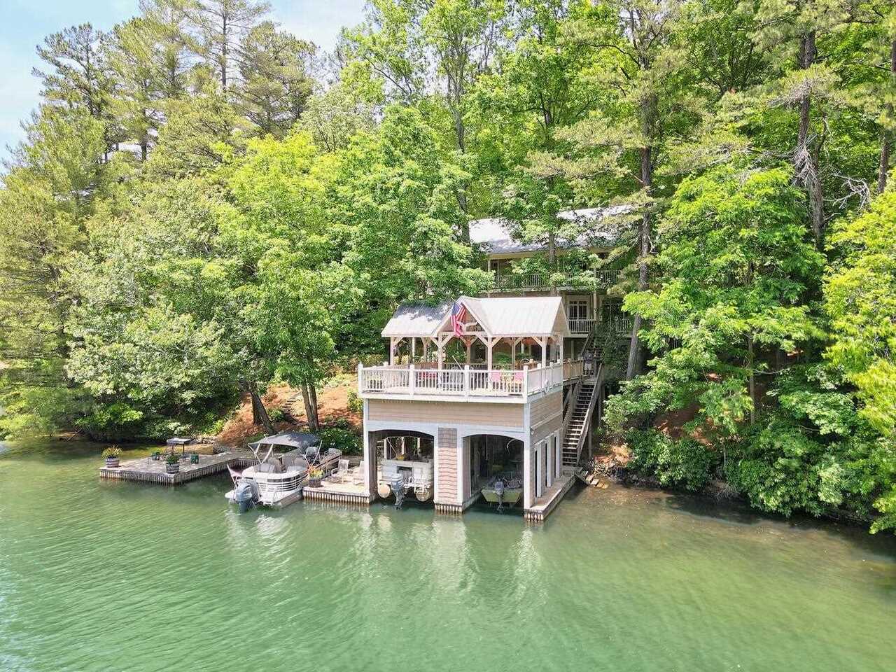 Come see this spacious Family Retreat on Lake Burton! Over 4,000 sq.ft built in 2005 for fulltime living and is sitting on a large lot 1.58 acres. It is the perfect Lake Burton home to bring family and friends to enjoy the lake and the North Georgia Mtns. 4/5 bedrooms, two of which have fireplaces in them, 4.5 baths, high ceilings, wide plank heart pine floors, tongue and groove wood ceilings, open concept kitchen, 3 fireplaces, 400 ft of lake frontage and easy access to the boat house are just a few of the pluses this property offers. Master bedroom suite on main level, spacious kitchen, dining and great room all open up to a lakeside porch perfect for rocking, grilling and entertaining. On the upper level there are 3 additional very spacious bedrooms which also all open up to the upper lakeside porch. The lake level has a bar area, living area/game room and potential 5th bedroom with a fireplace and access to outdoor lake level terrace. Nicely landscaped yard with a wonderful noisy babbling brook. All that is missing is you, fun and the laughter that will be abundant once this home is yours! Let the Summer begin!!!