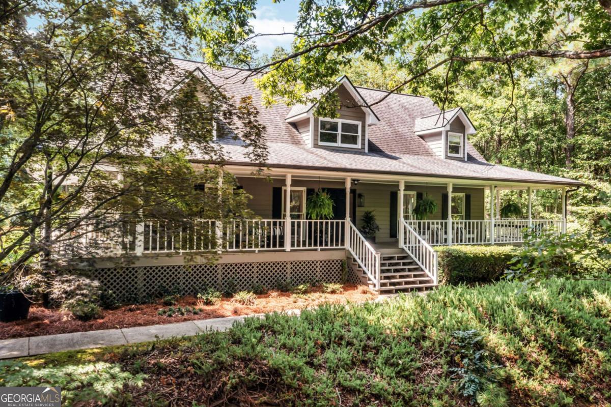 Set on two private acres, this thoughtfully designed home welcomes you with a classic wrap-around porch. With 3 bedrooms and 3.5 baths, each space showcases designer touches that elevate everyday living. The main level features hardwood floors, shiplap accents, custom oak built-ins, and elegant mouldings. The living room boasts a soaring cathedral ceiling open to the upper level and a cozy sun porch with views of the fenced backyard. The kitchen offers stone countertops, double pantries, and a bright breakfast nook that flows into an oversized dining room. The main-level primary suite includes a walk-in closet and a spacious bathroom with double vanities and a jetted tub. Upstairs, two secondary bedrooms share a large flex space filled with natural light and views of the manicured yard. The finished lower level offers a media room with a projector screen and theater seating. You will also find a full bathroom, ample storage, and two versatile bonus rooms with their own entry, ideal for a home office, gym, or creative space. Outdoors, enjoy raised garden beds, fruit trees, and a detached 2-car garage with a dedicated workspace. Additional features include RV or boat parking and an electric car charger. The architectural shingle roof is only 6 years old. With no HOA and a prime location just minutes from shopping, dining, LakePoint Park, Lake Allatoona, and I-75, this home truly offers it all. SHOWINGS BEGIN FRIDAY AUGUST 8th.