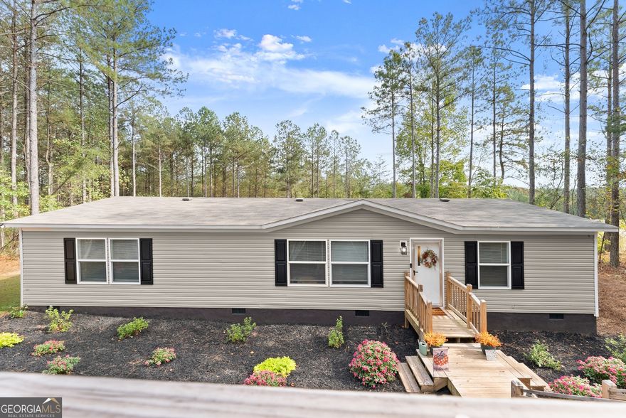 Welcome Home to Peaceful Ball Ground Living! Tucked away on 1.5 private acres in beautiful South Pickens County, this charming 3BR/2BA home-built in 2022 with no HOA-offers the perfect blend of peaceful country living and modern comfort. Step inside to find fresh interior paint, newly updated kitchen cabinets, and an open-concept layout that makes daily life easy and inviting. The spacious kitchen features an island, laminate counters, pantry, and a view to the family room-perfect for gathering with loved ones. The primary suite on the main level provides a cozy retreat with a walk-in closet and relaxing tub/shower combo. Additional highlights include laminate flooring, a convenient main-level laundry room, central electric heat and air, ceiling fans, and low-flow plumbing fixtures. Outdoors, enjoy a spacious back deck overlooking a wooded, landscaped backyard complete with a new retaining wall and a storage shed for all your tools and toys. The home sits on a permanent foundation (engineer letter available for financing) and features a large gravel driveway with plenty of parking for guests, recreational vehicles, or extra cars. Located near shopping and scenic trails, and just minutes from Ball Ground and Canton-this is the perfect place to unwind, spread out, and truly feel at home.