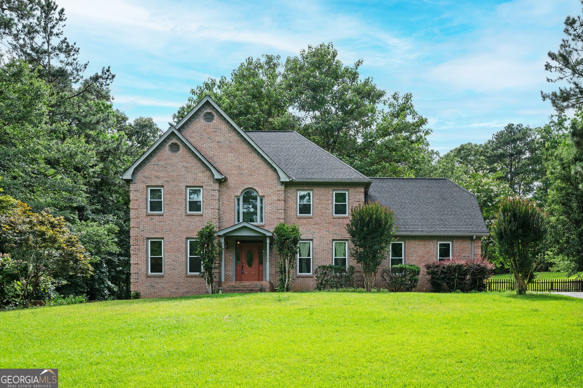 Experience the Perfect Blend of Privacy, Space & Elegant Design! Welcome to this stunning 3-sides brick traditional home situated on nearly 2 fully fenced acres, offering a rare combination of privacy, comfort, and refined design. Located behind a gated entry and nestled among mature trees, this 5-bedroom, 3.5-bath residence provides a peaceful retreat just minutes from city conveniences. Step inside to find a gracious open foyer with gleaming hardwood floors and a beautifully crafted staircase. The main level is thoughtfully designed for both daily living and entertaining, featuring: Gourmet kitchen with stainless steel appliances, pantry, and breakfast area Formal dining room for elegant gatherings Great room with fireplace, built-ins, and classic judge's paneling Cozy living room and bright sunroom that opens to an expansive rear deck, ideal for grilling or relaxing outdoors Upstairs, enjoy brand-new LVP flooring and fresh paint throughout. The spacious primary suite impresses with coffered ceilings, dual walk-in closets, and a spa-style bath complete with double vanities, a soaking tub, and a separate tiled shower. Three additional oversized bedrooms, an updated full bath, and an upstairs laundry room complete the upper level. The finished terrace level offers flexible living with a private bedroom, full bath, recreation room, wet bar, and an additional garage/workshop, perfect for guests, hobbies, or multigenerational living. Exterior features include: 2-car side-entry garage Detached storage shed Car/boat/camper awning Fully fenced backyard with deck views ideal for wildlife watching All major appliances, including washer and dryer, are included. Conveniently located just 5 miles from Atlanta Motor Speedway, near Trilith Studios, and only 22 miles from Hartsfield-Jackson International Airport, offering the ideal balance of seclusion and accessibility. Don't miss this rare opportunity to own a private estate that checks every box!