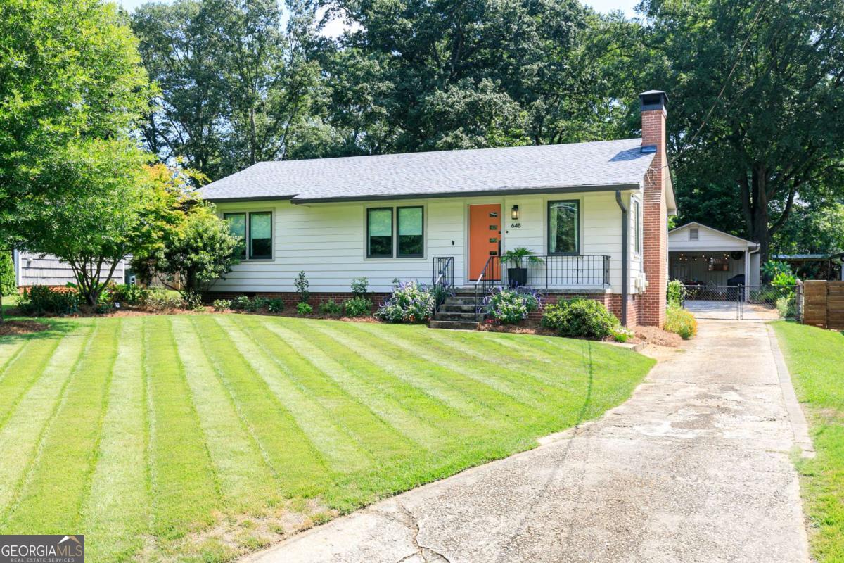 Welcome to 648 Etowah Drive-a charming ranch home perfectly situated on a beautifully landscaped .39-acre lot in the heart of Marietta. This residence combines timeless character with thoughtful updates, offering both style and convenience in one of the area's most desirable locations. Step onto the inviting front porch and inside, where gleaming hardwood floors and elegant crown molding set the tone. The spacious family room, anchored by a cozy stone fireplace, creates a warm and welcoming gathering space. The updated gourmet kitchen is sure to impress with white cabinetry, stone countertops, a stylish tile backsplash, and stainless-steel appliances. The sun-filled dining room, accented with crown and chair moldings, provides the perfect backdrop for everyday meals or entertaining guests. The private owner's suite offers a peaceful retreat with its own half bath. Two additional oversized bedrooms provide comfort with ample closet space. A beautifully designed full bath offers timeless tile throughout. Outdoors, this property truly shines. The lush, fenced yard offers plenty of space for gardening, play, or relaxation. The two-car carport doubles as a covered patio, making it an ideal spot for cookouts or enjoying quiet evenings. A separate workshop/storage room provides even more versatility for hobbies or projects. Location is everything-and this home delivers. Just minutes from Historic Marietta Square, you'll enjoy local shops, award-winning restaurants, farmer's markets, and festivals year-round. Wellstar Kennestone Hospital and top medical facilities are just around the corner, making this an excellent choice for healthcare professionals. Easy access to I-75 and I-285 ensures a smooth commute to Atlanta and beyond, while outdoor lovers will appreciate being near Kennesaw Mountain National Battlefield Park with its scenic trails and historic charm. Whether you're seeking charm, convenience, or outdoor enjoyment, this property offers it all. Don't miss your opportunity to own this well-maintained home in one of Marietta's most sought-after neighborhoods!
