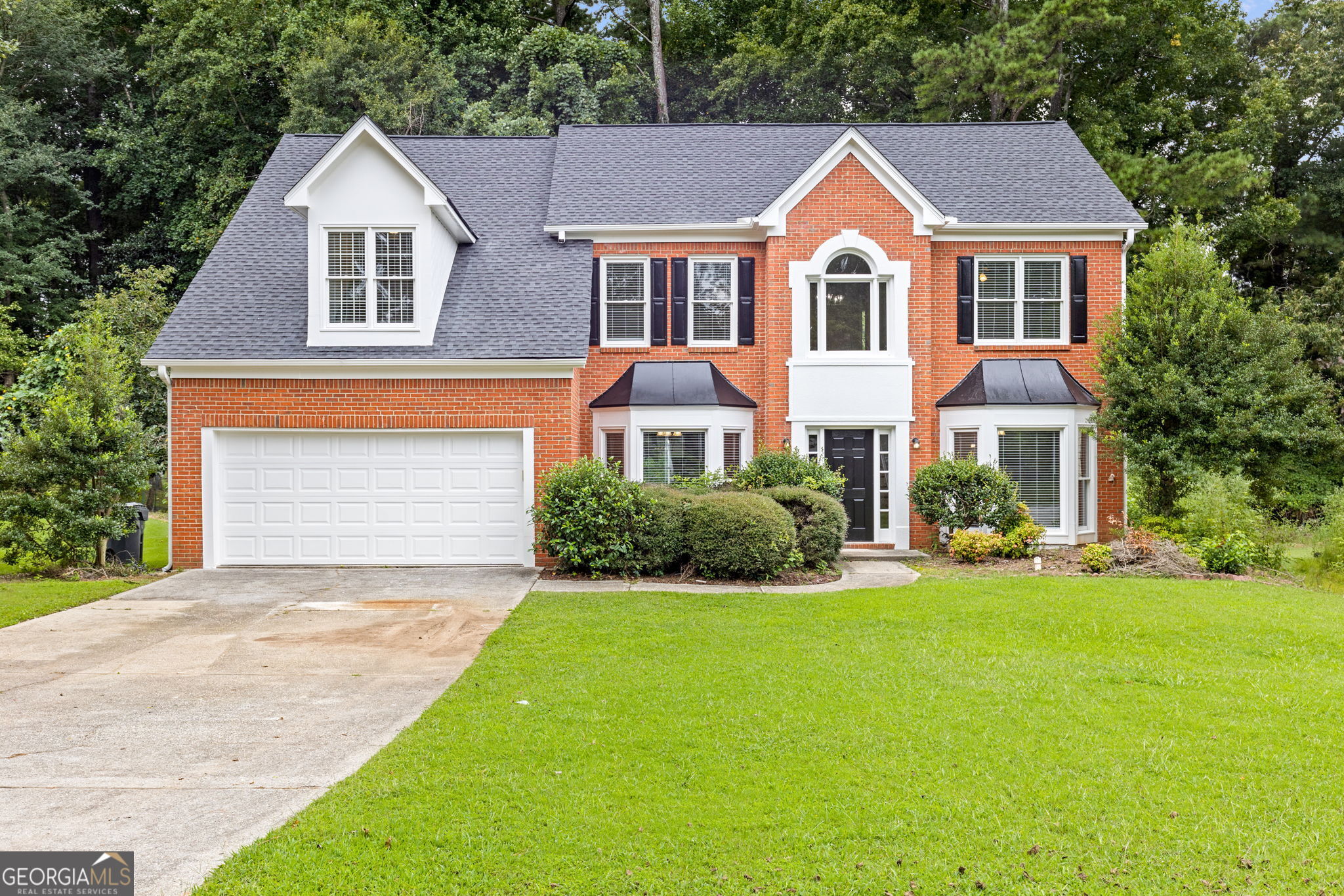 Fully Renovated & Move-In Ready Home with Main-Level Handicap Accessible Suite! Welcome to 9665 Knollcrest Blvd a beautifully updated 5-bedroom, 3.5-bath home located in the desirable Coldstream Courts neighborhood of Alpharetta (Johns Creek area). This home features a brand-new roof, new windows, fresh paint, new hardwood floors, and updated lighting throughout, offering the perfect blend of style, comfort, and accessibility. The thoughtfully designed main-level bedroom includes wide doorway access, and a private handicap-accessible full bath with a roll-in shower ideal for multigenerational living or guests with mobility needs. The bright, open main level also includes a welcoming two-story foyer, formal living and dining areas, and a cozy fireside family room that opens to a sunny breakfast nook. The fully updated kitchen features granite or quartz countertops, stainless steel appliances (including a new gas range), ample cabinet space, and a view into the private backyard perfect for gatherings, gardening, or play. Upstairs, you'll find the spacious primary suite with tray ceilings, a luxurious en-suite bath with soaking tub, separate shower, double vanities, and generous closet space. Two additional bedrooms share an updated hall bathroom, all with new carpet and paint. Additional upgrades include: new garage doors, updated HVAC, new water heater, new roof, and modern fixtures throughout. Nestled in a swim/tennis community with access to walking trails, playgrounds, and minutes from top-rated schools (State Bridge Crossing ES, Autrey Mill MS, Johns Creek HS), this home is just a short drive from GA-400, Avalon, Big Creek Greenway, and top golf and nature amenities.