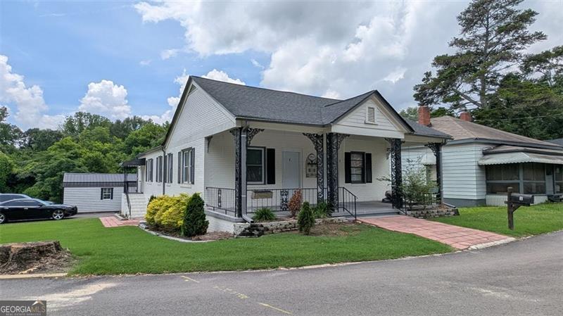 Welcome to this beautifully renovated four-sided brick ranch that offers the perfect blend of classic charm and modern updates. From the moment you arrive, you'll be captivated by the home's striking curb appeal, manicured landscaping, and inviting front yard. Inside, high ceilings and elegant hardwood floors create a warm, open feel throughout. The updated kitchen and bathrooms feature stylish finishes designed for both comfort and sophistication. Modern light fixtures enhance the contemporary aesthetic, while maintaining the cozy atmosphere of this thoughtfully upgraded home. Step out back and discover a fully fenced backyard oasis, complete with professional hardscaping, a wooden deck, and an oversized metal gazebo-ideal for outdoor entertaining or simply relaxing in a peaceful setting. A spacious covered front porch and a rare large driveway (a true gem in Porterdale) add both convenience and charm. Need extra space? The property includes a generous storage building, providing endless possibilities for hobbies, tools, or additional storage. Located in the heart of Porterdale, this home offers the best of small-town living with easy access to I-20-just minutes away for a seamless commute. Enjoy the tranquility of a close-knit community while staying connected to everything you need. Don't miss your opportunity to own this move-in-ready gem-schedule your private showing today!