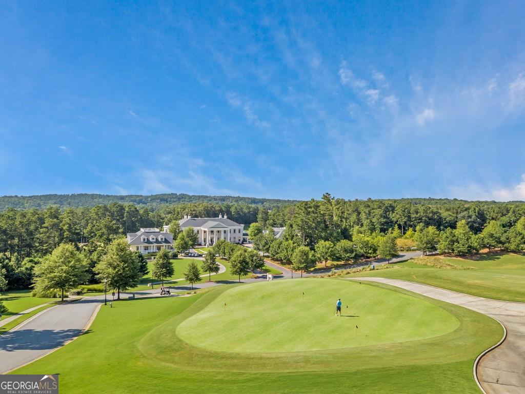 Presenting a rare opportunity to craft your dream home within the prestigious Governors Towne Club, Acworth's premier gated golf community. This corner lot, one of the last of its kind, offers a blank canvas for individuals seeking a lifestyle of unparalleled luxury and exclusivity. Picture waking up to breathtaking views of the 12th green and 13th fairway and winding down the day with unbeatable sunset views. The gently sloping topography of 4419 Oglethorpe Loop allows for a seamless daylight/walkout terrace level, ideal for entertaining or creating a private retreat. This rare corner lot offers the unique advantage of dual street access, enhancing privacy, convenience, and site plan options. With ample space for a custom pool, all your visions of resort-style living can become a reality. Governors Towne Club isn't just a location; living here provides the conveniences, relaxation and amenities of a resort. This masterly planned community caters to those who value the finest, offering: 24/7 manned gated access, allowing you to reside with absolute peace of mind. Engage in world-class golfing on an 18-hole championship course, masterfully designed by Curtis Strange, or unwind at the elegant clubhouse, where fine dining, a men's-only grille, and a grand ballroom await. Conduct business in the executive boardroom or connect with fellow residents at weekly member events. Prioritize your well-being at the luxury day spa and well-equipped fitness center, or engage in friendly competition on the eight lighted tennis courts and brand-new pickleball courts. The resort-style pool complex, complete with a tiki bar, children's pool, and water slides, guarantees endless summer enjoyment. An activity center, children's playground, softball field, and basketball court offer diverse recreational options. When it's time to go beyond the gates, Governors Towne Club is approximately twelve minutes from the interstate making commuting anywhere a breeze. Governors Towne Club is more than a residence; it's an investment in a lifestyle. This lot is a canvas for your vision, a place where success is celebrated and dreams are built. Contact me today to explore this exceptional opportunity and begin the journey to creating your dream home.