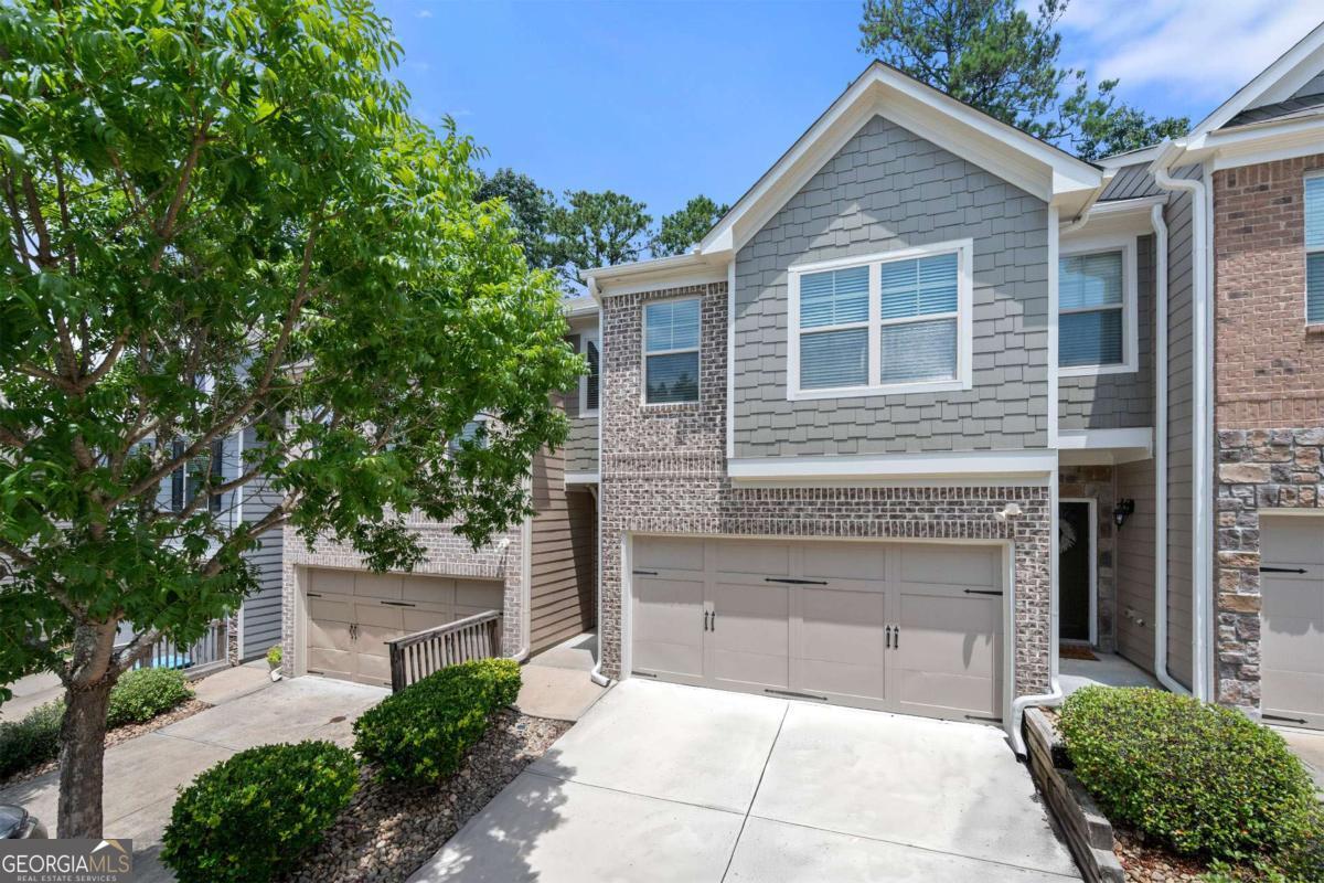 Welcome home to this inviting two-story residence. Step into a spacious family room where coffered ceilings and an electric fireplace set the tone for comfort and style. A decorative column adds character while providing a gentle separation from the dining area, making the space feel open yet distinct. Beautiful hardwood floors and 9-foot ceilings throughout the main level enhance the overall warmth and flow of the home. Just off the living area, the kitchen offers both function and charm, featuring a large center island, walk-in pantry, double sink, and ample counter space-ideal for everyday meals or weekend gatherings. Upstairs, the primary suite includes a relaxing sitting area, a spacious walk-in closet, and a bathroom with tile flooring, dual vanities, and a separate tub and shower. Fresh interior paint throughout gives the home a clean, updated feel. Located near shops and restaurants and less than 10 minutes from Stone Mountain Park, this beautiful stone and brick unit is tucked away in a quiet, well-kept community with easy access to Hwy 78.