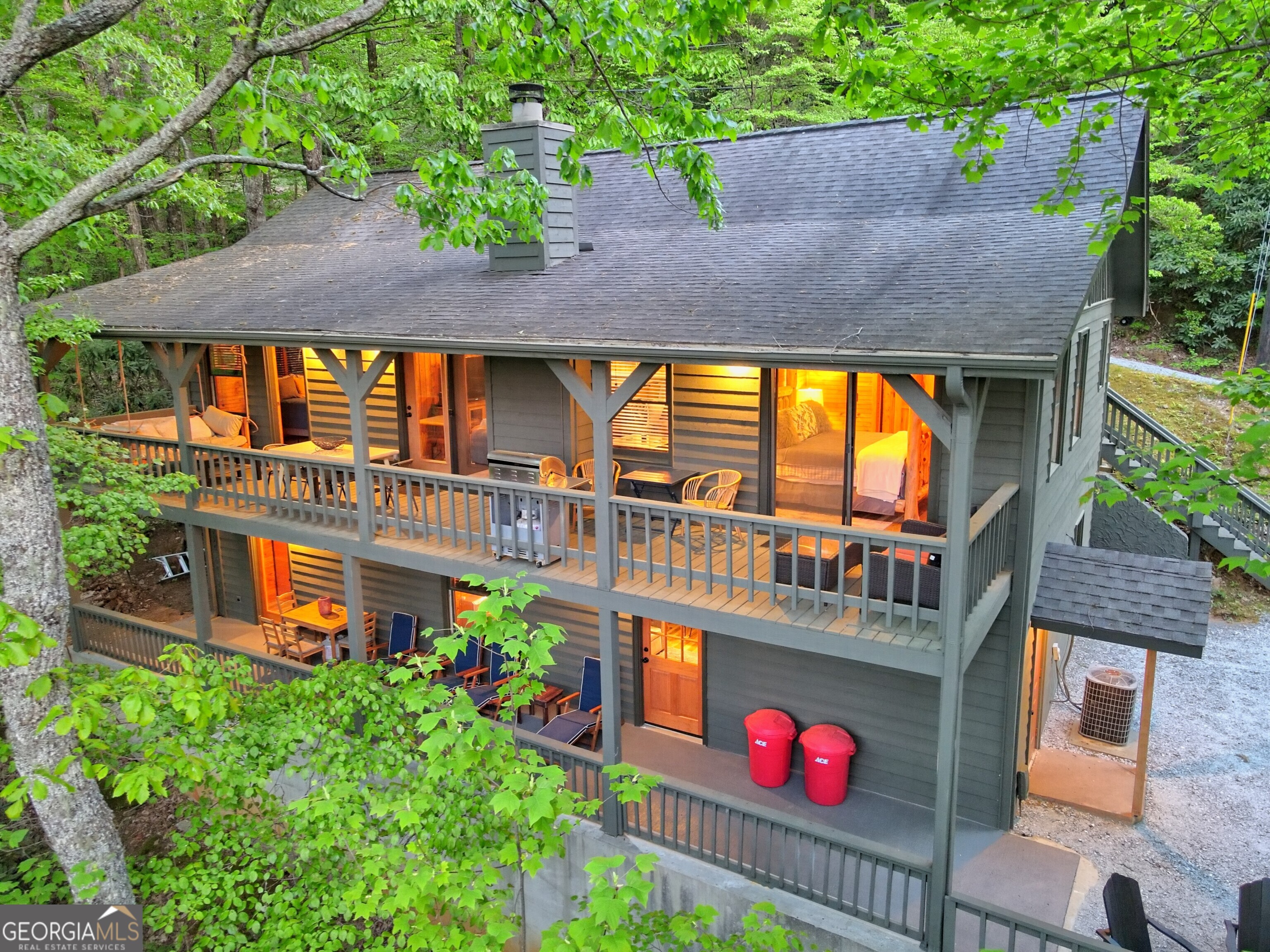 This beautiful mountain home retreat is hidden high atop scenic Screamer Mountain; fully refurbished to reflect its natural setting, with modern, sophisticated finishes at every turn. The entire home has new wood laminate flooring throughout, as well as knotty pine wall planks. The main kitchen has been remodeled with new cabinetry, Quartz counters, a custom-built rustic dark oak island, and brand-new stainless-steel appliances. The cabinetry has also been added in the adjacent dining room for optimal storage of dishware. Nearby, the wooded great room has a stone fireplace and bone-color antler chandelier high above. As you head downstairs, you will find a remodeled wreck room (all furnishings and electronics are new and included), as well as a kitchenette/wet bar for entertaining galore. Discover a secret bedroom, hidden behind the kitchenette shelving! This bedroom has been creatively decorated as a charming camping-style room. The remaining three bedrooms are all wooded and beautifully decorated, two with dramatic king size beds. The primary bedroom has a large sliding glass door that provides incredible mountain views, as well as private vanity and bathroom. All three full bathrooms in the home have been remodeled with new vanities, toilets, fixtures, black matte hardware, and wooded tub sides. This mountain home has two large back porches, both with glorious views of the Georgian mountain landscape. An entire sauna room has been added to the home, right off the lower porch. With the quaint, yet vibrant town of Clayton just 5 minutes down the mountain, as well as wineries, galleries, hiking, rafting, and other activities nearby, this home is perfect as a year-round residence, a second home escape, or a vacation home rental. Discover a true original.