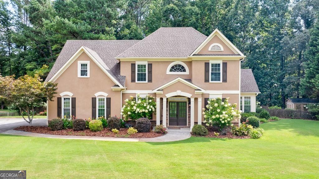 Happiness Has an Address...right here in the popular Fox Creek Community! Welcome to this beautifully livable 4 bedroom 2.5 bath home on truly one of the best lots in the community. This open concept main floor design offers 2 separate living areas plus the most beautiful light-filled sunroom overlooking this beautifully landscaped property. Have some fun in the fully fenced back yard, enjoy evenings on your private deck with awning or cozy up on the additional patio. Plenty of extra storage in the side entry garage plus the separate storage building. The kitchen offers custom 42" soft close cabinetry with granite countertops, gas cooktop and stainless steel appliances. Beautiful hardwood flooring completes the main floor and recently replaced energy efficient double pane windows make this an even smarter choice. You'll love the beautiful owners suite with private deck, sitting area and luxury bath too. The Fox Creek community offers top notch award winning schools plus the community amenities you're looking for such as a playground, tennis courts, pool, and walking trails. You'll be minutes away from Vickery Village, Halcyon, Cumming City Center and The Big Creek Greenway with easy access to Milton and Alpharetta as well. What are you waiting for?