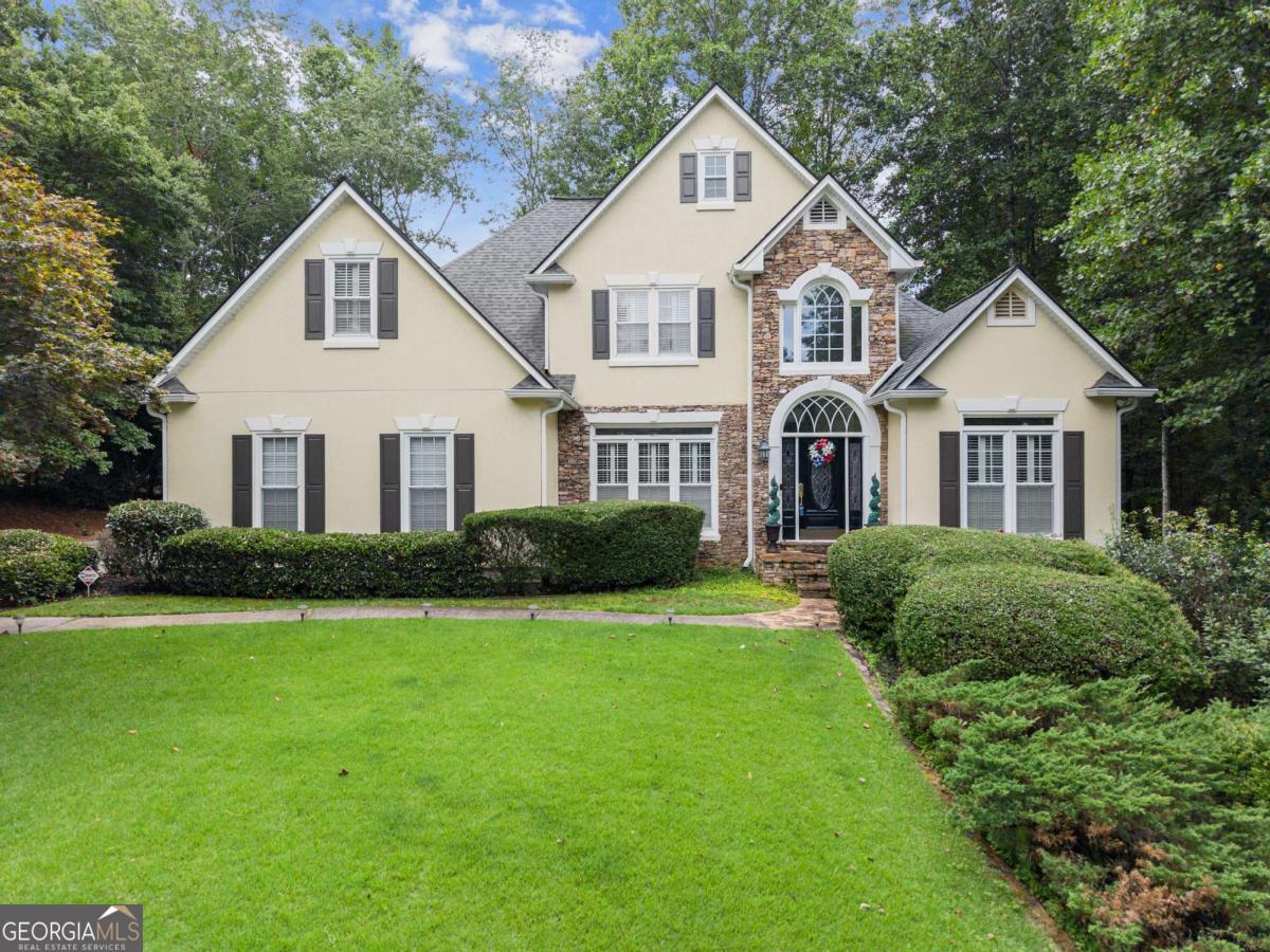 Stunning 2-story home on a 0.75-acre culdesac lot with lush landscaping in a desirable North Hall neighborhood. This beautifully maintained home features a recently painted exterior, 4 bedrooms, 2.5 baths, a welcoming front porch, back deck, partially finished basement, and a 2-car side-entry garage. The oversized primary suite is located on the main level and offers vaulted ceilings, a bathroom with double vanities, soaking tub, separate shower, and a large custom-designed closet. The great room showcases a gas fireplace with gas logs, tall ceilings, and beautiful windows that fill the space with natural light. The formal dining room features elegant wainscoting and trim and comfortably seats 12 or more guests. The fully equipped kitchen, including the refrigerator, offers a spacious breakfast area perfect for gathering with family and friends. A large office on the main level accommodates two desks with additional room for seating or storage. The conveniently located laundry room includes a washer and dryer, utility sink, abundant storage, and a laundry chute from upstairs. A catwalk on the upper level overlooks the great room below and leads to three additional bedrooms, a full bath, a linen closet, and a large walk-in closet. The partially finished basement includes a recreation area with a pool table, a TV room, and a bar area, plus two storage rooms-one with outdoor access. Additional highlights include an extensive trim package, plantation shutters on all windows, all-wood flooring throughout the main level, a tankless water heater, irrigation system, and three HVAC units (two recently replaced), along with a new air handler and new furnace. Located in the highly sought-after North Hall area, this home combines comfort, functionality, and timeless charm.