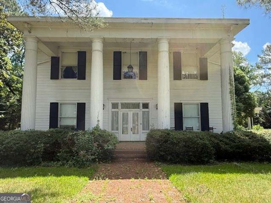 Step into a timeless treasure with this stunning, over 100-year-old historic home originally built on Love Avenue in 1890. Relocated in the 1970s to its prominent corner lot on Wilson Avenue, this residence is not just a house - it's a piece of Tifton's living history. With deep community roots, 2205 Wilson has ties to many of Tifton's most r citizens. Inside, you'll find 6 spacious bedrooms - including 2 on the main level - offering abundant space for family, guests, or flexible living arrangements. From soaring tall ceilings, elegant interior columns, and vintage wallpaper to custom oversized windows and intricate crown molding, every detail invites warmth and charm - ideal for gracious living and memorable entertaining. Enjoy formal living and dining rooms, a cozy separate parlor, and a stately brick front porch with four grand wooden columns, a true showstopper that adds to the home's commanding curb appeal. This home does require some restoration to bring it's glory.
