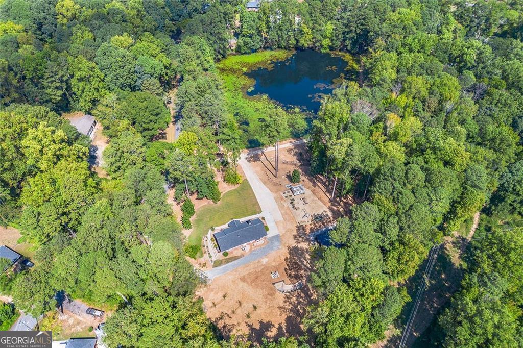 Welcome to this extraordinary once-in-a-lifetime opportunity to make this 3-bedroom, 2-bathroom house your HOME! Boasting 1,850 square feet of beautifully upgraded living space on a professionally landscaped 7.5-acre East Cobb Marietta property. With a 2-acre private fishing lake featuring a floating dock, new drainage system, and an aeration setup, this home offers a tranquil and self-sufficient lifestyle perfect for families, homesteaders, or potential Airbnb hosts. The property is a true outdoor retreat, featuring a dedicated outdoor recreation area with four camping spots, a walking trail, an outhouse, a fishing house with a grill area and deck, a she-shed/greenhouse with power and water, a huge barn/storage shed, and wine and grain storage/ root cellar. Inside, you'll find original hardwood floors throughout most of the home. The open floor plan is filled with natural light, centered around a modern, updated kitchen complete with premium appliances, reclaimed wood shelving, and a garden kitchen window. The home also includes thoughtful touches like a coffee bar with built-in mini fridge, hanging pot cabinet, and an easy access laundry setup. Upgrades include a new roof, new windows, spray foam insulation throughout, new main water line, durable epoxy flooring, new fixtures throughout, new plumbing and gas lines, new electrical wiring and electrical panel, and a tankless hot water heater with a recirculating system. For storage and convenience, the attic-spanning the same square footage as the home-is easily accessible via a 500-pound capacity freight elevator, making moving and organizing a breeze. Additionally, the property includes raised garden beds with irrigation, an orchard with pear, apple, and peach trees, and a barn equipped with power and water. Despite its feeling of seclusion, this property is just minutes from popular dining, shopping, major interstates, and offers easy access to the Atlanta Airport. I-75 is literally about 2 minutes away! Whether you're looking for a peaceful family retreat, lots of wildlife and great fishing or a unique Airbnb opportunity, this home has it all. Property also has multiple buildable lots.