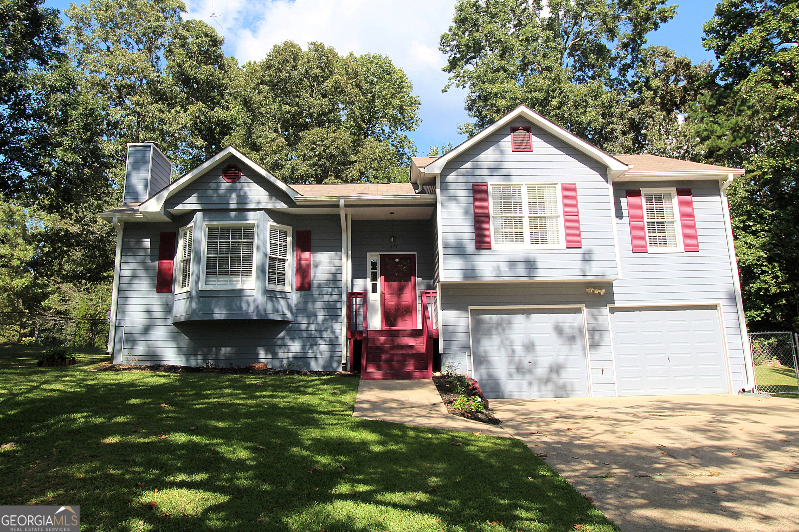 Rare find on almost 1/2 ACRE! One of the largest lots in the neighborhood and one of the larger floor plans! Newer carpet throughout (1 year), interior painted throughout (including dark trim), newer luxury vinyl in both baths and kitchen! Newer fixtures throughout including toilets, lighting, switchplates, door hardware and more! Adorable country kitchen has ample cabinets and stainless steel appliances. Gas range, vent hood and dishwasher are 1 year old. Large primary bedroom has a dressing area and walk-in closet. Roomy secondary bedrooms. The living room has a vaulted ceiling and a wood burning fireplace with gas starter. Newer blinds and window treatments throughout including roman shades. The basement has great features, daylight in back and partially sheet rocked. This basement is clean and dry - maybe a gym or man pit? Oversized 2-car garage has room for a workshop and plenty of storage. The parking area can be HUGE if you have a boat, camper or work vehicle, this is for you! Huge sunny deck is rustic and so enjoyable with all-day sun and peaceful mornings and evenings. The back yard is fully fenced with a double-gate and a single gate. The HUGE outbuilding has electric and endless possibilities. Stored here are storm windows for all windows of the house (except the kitchen window). The neighborhood has NO HOA, it is friendly and quiet, convenient to Dallas, Cartersville and Acworth. Great new schools in the area too. Schedule your showing today, you won't be disappointed!