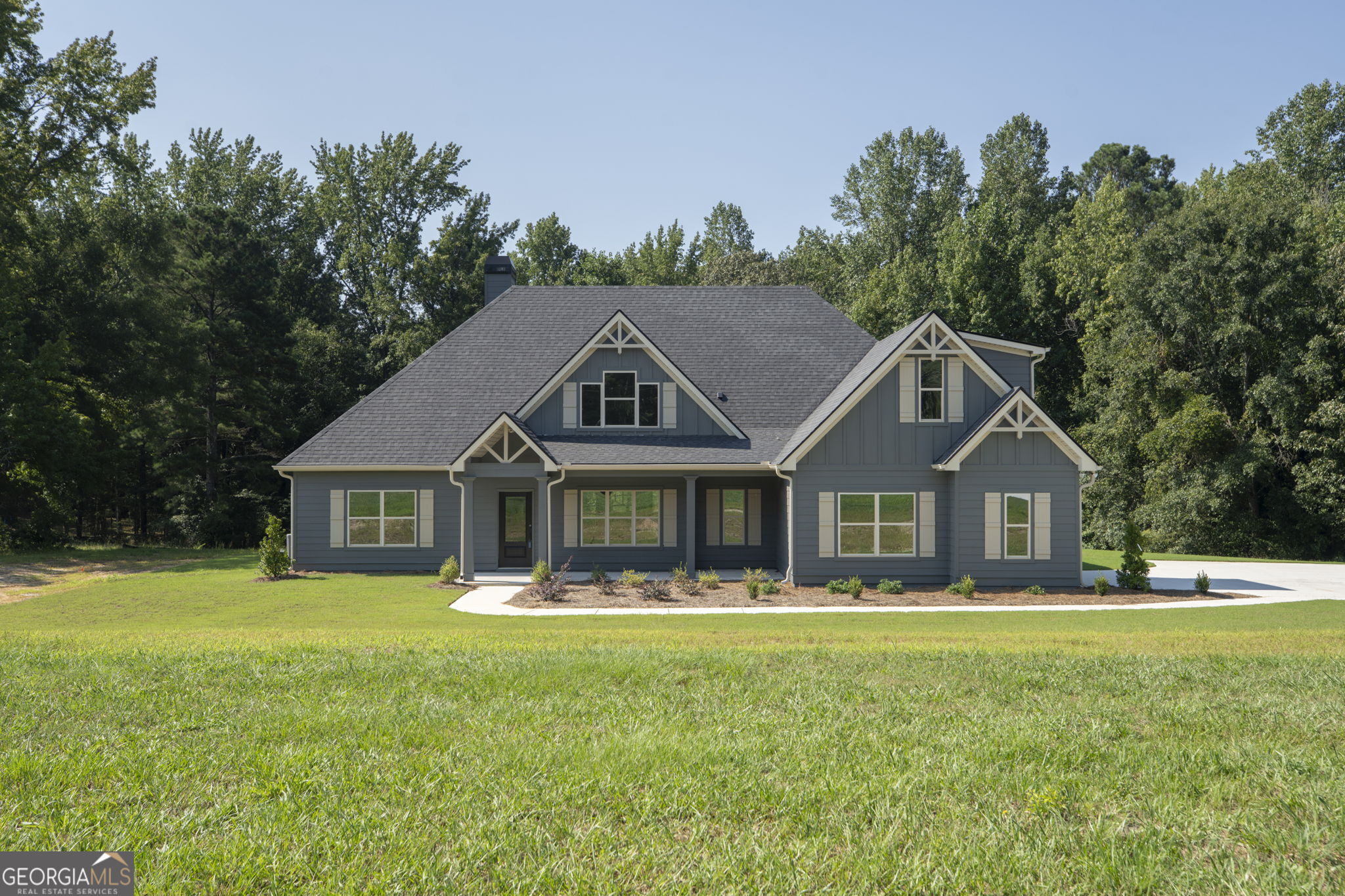 Location! Location! Location! Nestled on a beautiful 4.5 acre lot, this incredible home offers the perfect blend of privacy and convenience in a prime North Spalding County location. Just 27 miles from Atlanta International Airport, you'll enjoy the serenity of country living without sacrificing access to city amenities. With fiber internet available, this home is ideal for remote work or staying connected in today's fast-paced world. The Addison plan by Trademark Quality Homes is a highly sought-after plan, and it's easy to see why! This spacious, 4 bedroom, 3.5 bathroom home boasts a split bedroom design that provides the perfect layout for both comfort and privacy. Upon entering, you are greeted by a welcoming foyer and a powder room, perfect for guests. The spacious great room features a cozy stone surround, wood-burning fireplace and vaulted ceilings complete with gorgeous wood beams, creating a warm and inviting atmosphere. The gourmet kitchen is a chef's dream, offering an open concept layout with a sunny breakfast area, formal dining room, and luxurious designer finishes throughout. Carrara Morro quartz countertops, a tiled backsplash, stainless steel appliances including a wall oven, separate cooktop, dishwasher, built-in microwave & vent hood, and sleek modern glass pendants complete this space. Whether you're preparing an every day meal or hosting guests, this kitchen will impress and flows conveniently through to the formal dining room. The spacious primary suite on the main level is a true retreat, featuring a tray ceiling and a private bath with double vanity, carrara morro quartz countertop, a huge walk-in closet, a separate free-standing tub, and a tiled shower. Two additional guest bedrooms, a full guest bath, and a laundry room are also conveniently located on the main level. Upstairs, you'll find a large bonus room, a perfect space for a home office or media room, along with another guest bedroom and a full bath-ideal for privacy and comfort. Relax and enjoy the tranquility of your surroundings from the rocking chair front porch or covered back patio. With over 4.5 acres of wooded beauty, there's plenty of room to explore, entertain, or simply unwind. Don't miss the smart home features: keyless deadbolt, select smart switches, video doorbell & more. Builder requires a 2% construction deposit and offers a $2,500 credit with use of a preferred lender - plus an additional $2,500 from the lender! Don't miss your chance to own this exceptional home in one of the most desirable locations in North Spalding County. Contact the listing agent today for more details!