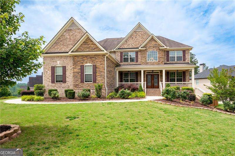 Schedule an appointment to view this gorgeous executive home that boasts 5 bedrooms and an unfinished basement on a corner lot! Renovations include new carpet throughout, new interior paint, freshly painted kitchen cabinets, newly installed built-ins in the great room, refinished hardwoods, electric blinds, tinted family room windows, tinted back door, newly stained deck, fence and a firepit sitting area. The two-story foyer and gleaming, refinished hard woods will great your guests. The chef's kitchen is appointed with freshly painted cabinets, new pendants, stainless steel appliances to include a new refrigerator and dishwasher, granite countertops, tile backsplash, and an oversized island with seating. The kitchen opens to the sunny side eat in area with a new light fixture and the keeping room that features a vaulted ceiling, wood beams, and a brick fireplace and to the sunny eat in area. The open floor plan continues with the great room that boast, new hardwoods, a beautiful wall of windows, brick fireplace, and new built ins. The dining room features a new light fixture, trey ceiling, and wainscoting and is ready to host your dinner parties. The formal living room is perfect as a home office. Your guest will enjoy their time in their private ensuite that is appointed with new paint and new hardwoods. The second floor features the primary suite with a sitting area, trey ceiling, French doors, an oversized closet, granite counters, dual vanities, jetted tub, walk in shower, and a frosted window. There is another ensuite with a tiled shower and granite countertop. There are two additional bedrooms that share a Jack-n-Jill bathroom with a tiled shower and granite counters. Relax on your covered front porch and enjoy the sunset. The deck overlooks the private, level backyard. There is plenty of room for a pool or playset. You will enjoy your evenings by the firepit. There is a double gate on one side of the fence and single gate on other side. The basement is ready for your design and special touch. The three car garages are side entry and have extra height doors. The neighborhood is a conservation area with ample greenspace, featuring a fishing lake with dock, walking trails, pocket parks, Junior Olympic pool, kiddie pool with 4 mushroom waterfalls, clubhouse, playground, 6 lit tennis courts, basketball court, pickleball complex, and a vibrant social community. Enjoy the closeness to the North Georgia Mountains, Lake Lanier, and the North Georgia Premium Outlet Mall, adding to the unbeatable lifestyle this home offers.