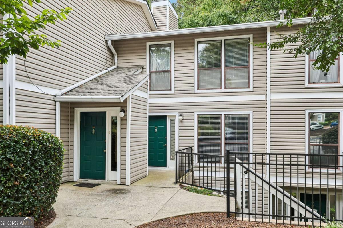 Welcome home to this spacious 2-bedroom, 2-bath condo conveniently located in Wynne's Ridge swim and tennis community. This home offers an open floor plan with natural light throughout. The main living room features a cozy gas fireplace with built-in shelving, and sliding doors open to a private patio-perfect for morning coffee or evening relaxation. The primary suite includes an updated en suite bath and a walk-in closet, providing both comfort and functionality. The secondary bedroom also offers ample size with its own private en suite, making it ideal for guests, family, or a roommate setup. The kitchen has been updated with white cabinetry, stainless steel appliances, granite countertops, and a peninsula that flows seamlessly into the dining and living areas-ideal for entertaining or everyday living. Additional highlights include new hardwood flooring throughout, a large pantry, separate laundry room, and walk-in level access for convenience. The property is also located just minutes from The Battery, I-285, I-75, shopping, dining, and more!