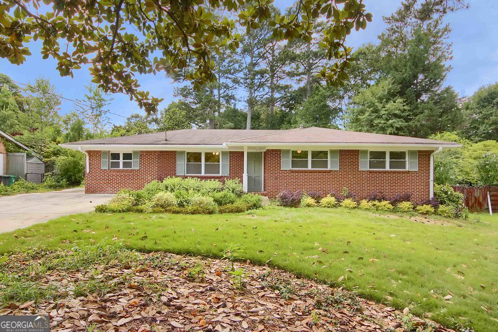 Charming 1960s ranch in a prime Tucker location,offering surprising space,flexibility,and inviting indoor-outdoor living. This 3-bedroom,2-bath home features a spacious addition, ideal as a great room,studio or flexible living space. The eat-in kitchen opens to a wet bar area perfect for casual entertaining or family gatherings. Two sky light sun lit rooms areas provide so much flexibility, with one off the primary bedroom-ideal as a home office, gym, or quiet retreat and the other extending the living and entertaining space both opening to the outside. Freshly painted inside. Updated Kitchen. Bathrooms retain their vintage charm and offer a great opportunity for cosmetic refresh. Hardwood and tile floors throughout (wood floors need some TLC).Outside, enjoy professionally landscaped grounds with lush Zoysia grass, a private fenced backyard with hardscaped fire pit area offering multiple spots to relax or entertain.Extra wide driveway allows for plenty of parking options.Additional highlights include an enclosed carport with laundry area and a backyard storage shed. All this in a fantastic Tucker location close to schools, parks, shopping, and dining. A rare blend of space, charm, and potential!