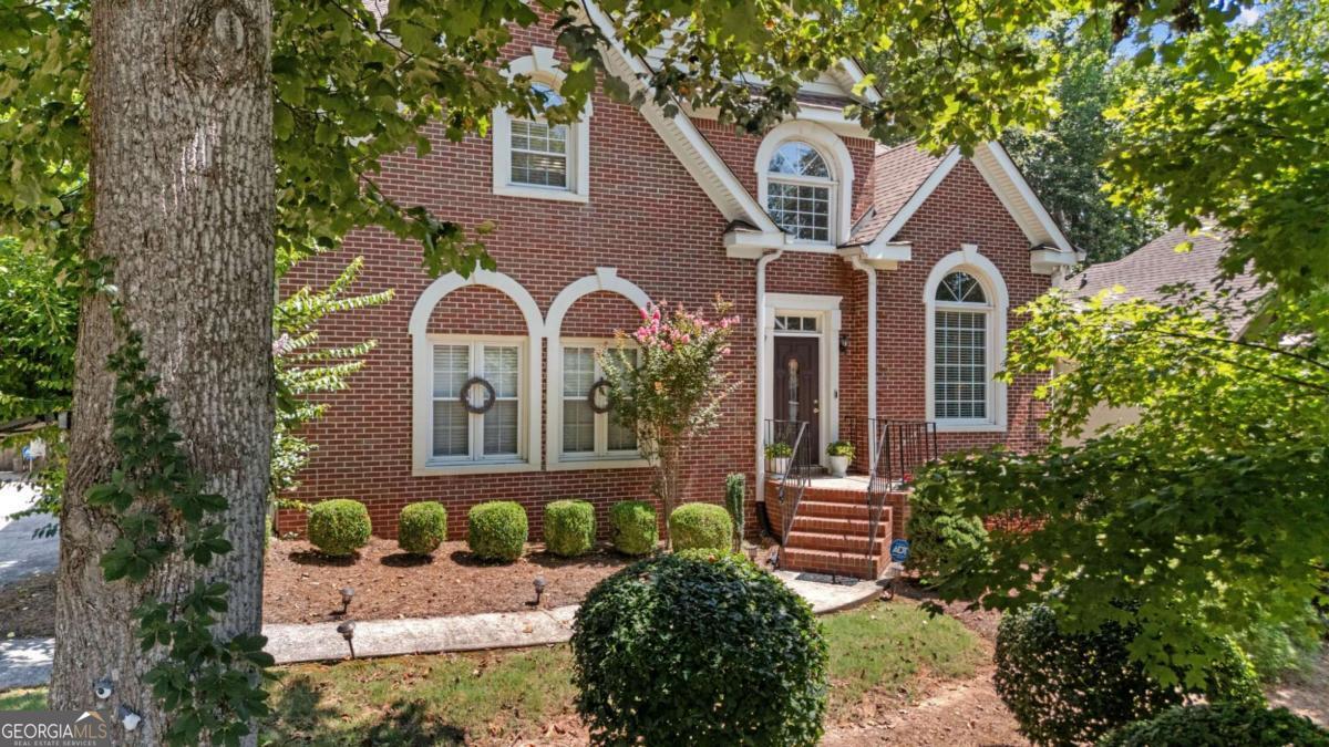 This stunning brick-front beauty in Marietta's most desirable locations and in Hillgrove HS checks all the boxes! This well-maintained home offers a perfect blend of classic charm and modern comfort, beginning with a soaring two-story foyer that opens into the formal living room flooded with natural light-an ideal space for gatherings and entertaining. The adjoining formal dining room sets the stage for elegant holiday meals, while luxury vinyl plank flooring flows seamlessly throughout the main level, adding warmth and durability. The chef's kitchen features granite countertops, stainless steel appliances, ample cabinetry, and a window above the sink for added light and views. Just off the kitchen is a spacious casual living area anchored by a cozy brick fireplace and framed by a wall of windows overlooking your private backyard oasis. Upstairs, unwind in your oversized primary suite with trey ceilings and a generous en-suite bath that includes dual vanities, a soaking tub, and a separate shower. Three large secondary bedrooms offer flexibility for guest space, a home office, or kids' rooms. But the real bonus is downstairs! The finished basement is a true entertainer's dream, complete with a home theater with stadium seating, a custom bar, and space for arcade games or a pool table-perfect for game nights and weekend fun. Enjoy Georgia summer bbq's on your back deck while kids or pets play in the large, level backyard. Community amenities include a swimming pool, tennis courts, playground, and walking trails to Kennesaw Mountain. Located across from Cheatham Hill Elementary and just minutes to Marietta Square, Publix, Kroger, Target, and Home Depot-everything you need is right at your doorstep.